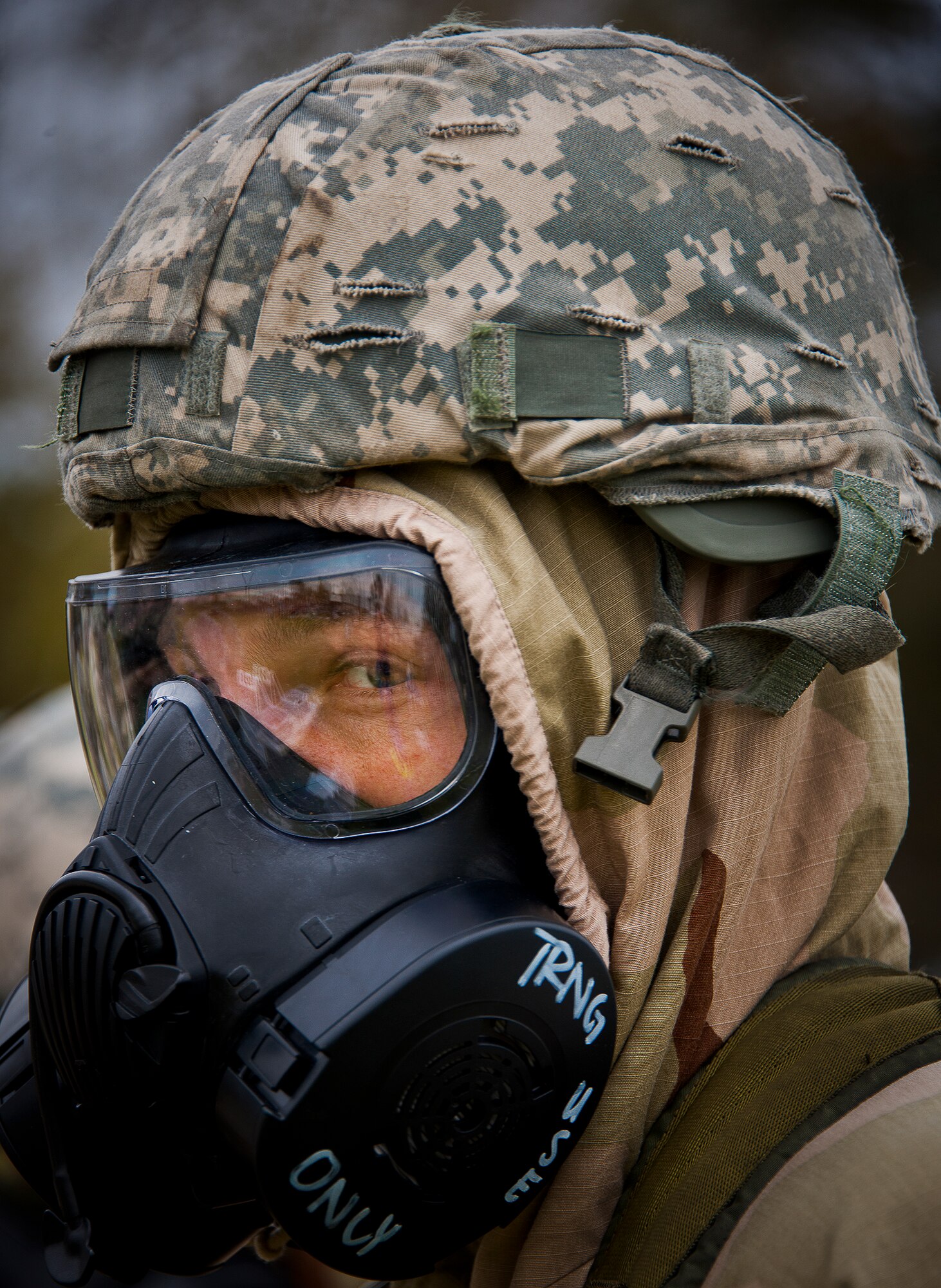 An Airman in MOPP-4 gear listens as his instructor explains the next scenario during the field training portion of a Phase II exercise March 20 at Eglin Air Force Base, Fla. A Phase II evaluates a unit's ability to meet wartime and contingency taskings of employing the force, sustaining the force and the ability to survive and operate.  More than 75 deployers, in two groups, received classroom and practical field training over March 20-21 to meet the readiness requirement.  (U.S. Air Force photo/Samuel King Jr.) 