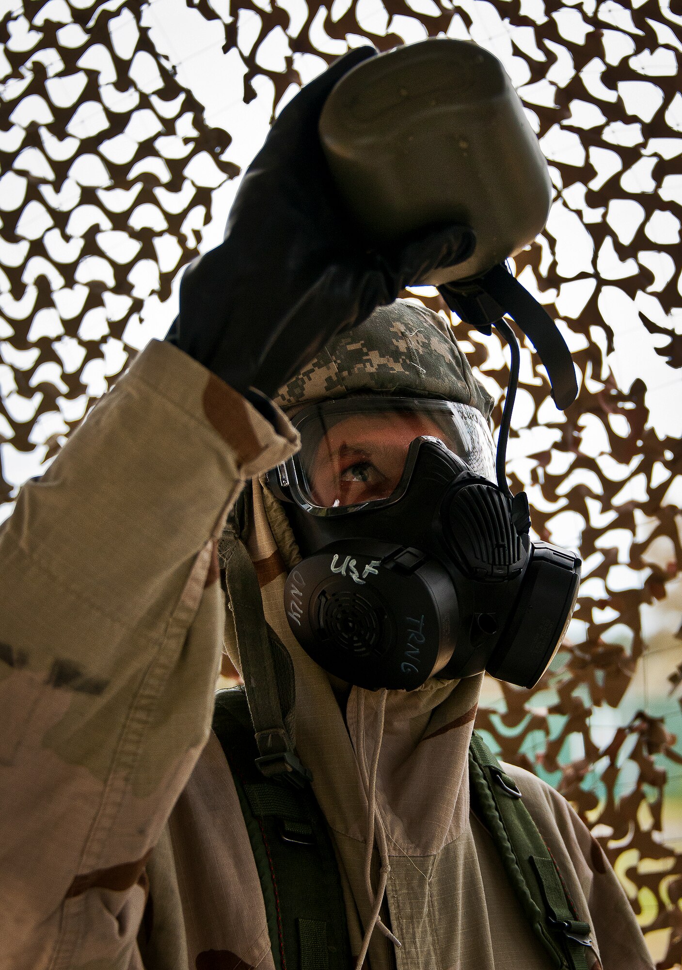 An Airman drinks from his canteen while wearing his M-50 gas mask during the field training portion of a Phase II exercise March 20 at Eglin Air Force Base, Fla. A Phase II evaluates a unit's ability to meet wartime and contingency taskings of employing the force, sustaining the force and the ability to survive and operate.  More than 75 deployers, in two groups, received classroom and practical field training over March 20-21 to meet the readiness requirement.  (U.S. Air Force photo/Samuel King Jr.)