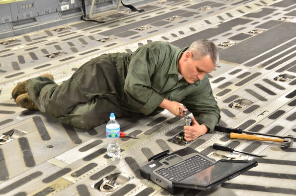 WRIGHT-PATTERSON AIR FORCE BASE, Ohio - Master Sgt. Ty Walk, 445th Maintenance Squadron aerospace repair craftsman, makes repairs to the floor in the cargo area of a C-17 Globemaster III during a routine Home Station Check inspection Feb. 21. (U.S. Air Force photo/Stacy Vaughn)