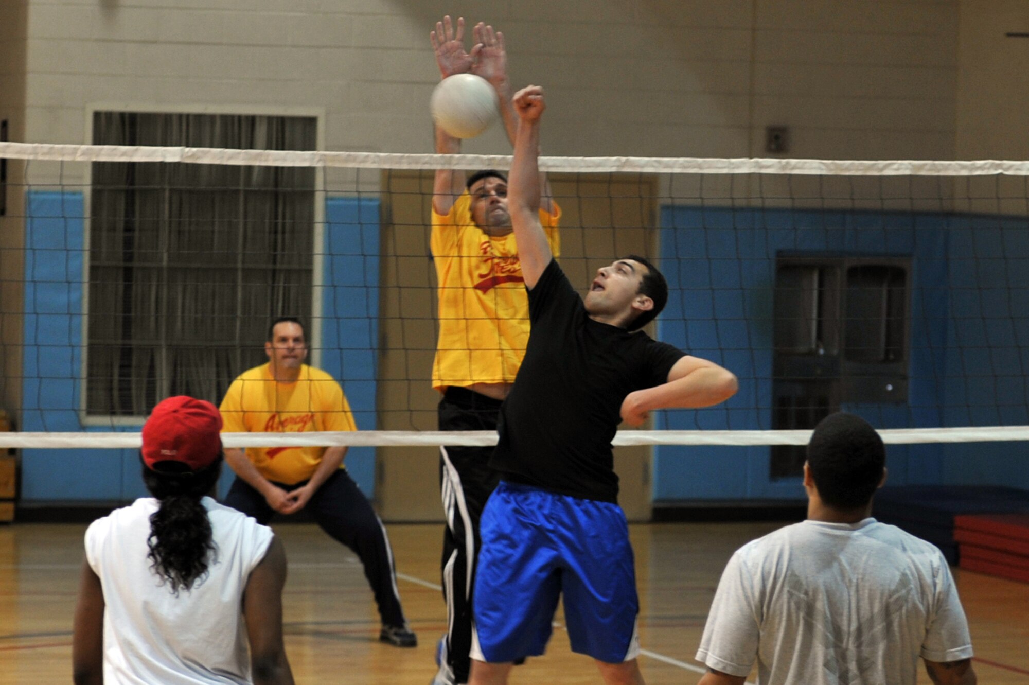 Command Chief Master Sergeant Scott Delveau (left), 7th Air Force command chief, blocks a spike from Senior Airman Jeffery Bowen, 51st Maintenance Squadron member, in the Battle of the Tiers volleyball tournament at the Osan Fitness Center on Osan Air Base, Republic of Korea, March 29, 2013. The Chiefs Group eliminated the Osan Junior Enlisted Council in the tournament. (U.S. Air Force photo/Senior Airman Alexis Siekert)