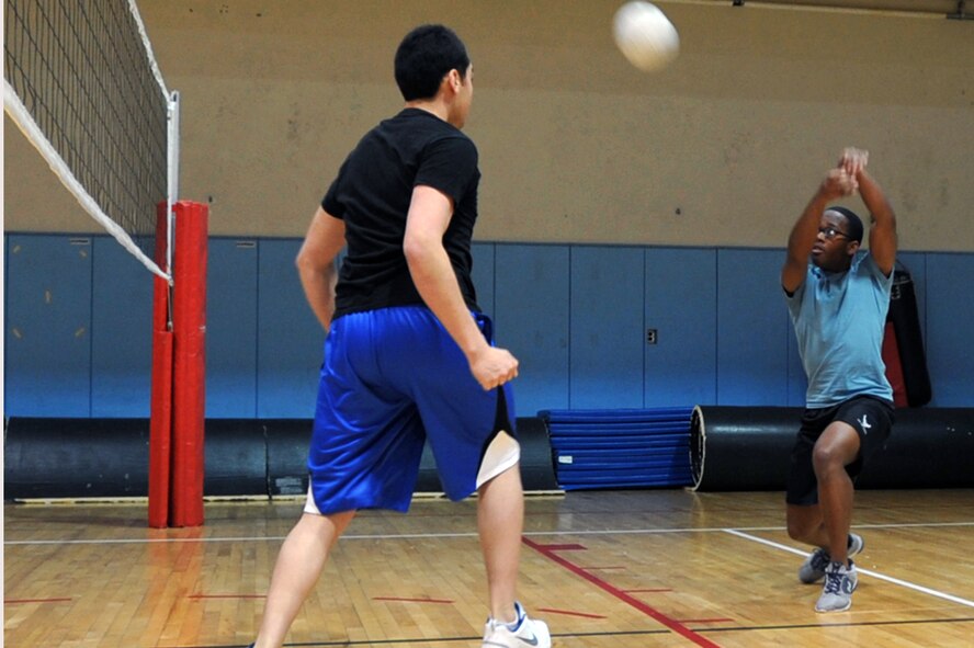 Players from the Osan Junior Enlisted Council team return the ball in the Battle of the Tiers volleyball tournament at the Osan Fitness Center on Osan Air Base, Republic of Korea, March 29, 2013. The OJEC team defeated the Company Grade Officer team. (U.S. Air Force photo/Senior Airman Alexis Siekert)