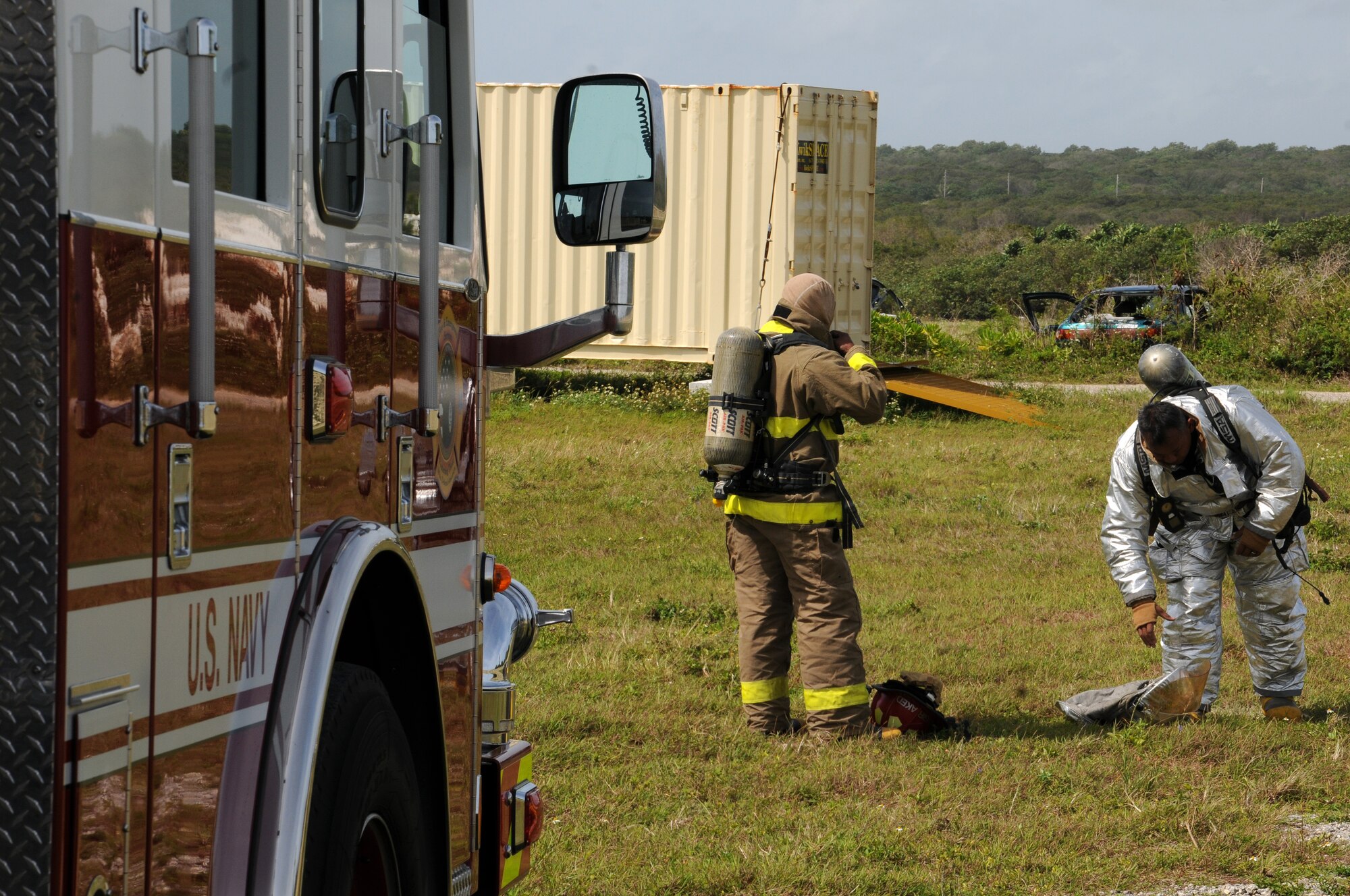 Tech. Sgt. Richard Benavente (right), 36th Civil Engineer Squadron Fire and Emergency Services NCO  in charge of training, and a Saipan fire officer suit up before a structural fire exercise on Andersen Air Force Base, Guam, March 27, 2013. Andersen Fire and Emergency Services personnel hosted four Saipan fire officers for joint fire training during their visit to Guam March 25-29. (U.S. Air Force photo by Staff Sgt. Melissa B. White/Released)