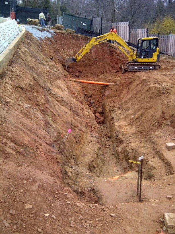 Crews excavate the backyard of 4825 Glenbrook Road for relocation of site utilities and as preparation for the installation of the soldier piles and engineering controls for high probability work.  