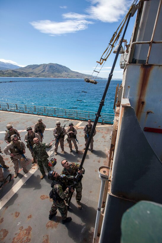 26th Marine Expeditionary Unit (MEU) Maritime Raid Force Marines watch as instructors assigned to the NATO Maritime Interdiction Operational Training Centre demonstrate vessel boarding techniques with a climbing ladder aboard the HS Aris at the in Souda Bay, Crete, Greece, March 27, 2013. The 26th MEU is deployed to the 6th Fleet area of operations. The 26th MEU operates continuously across the globe, providing the president and unified combatant commanders with a forward-deployed, sea-based quick reaction force. The MEU is a Marine Air-Ground Task Force capable of conducting amphibious operations, crisis response and limited contingency operations. (U.S. Marine Corps photo by Cpl. Christopher Q. Stone/Released)
