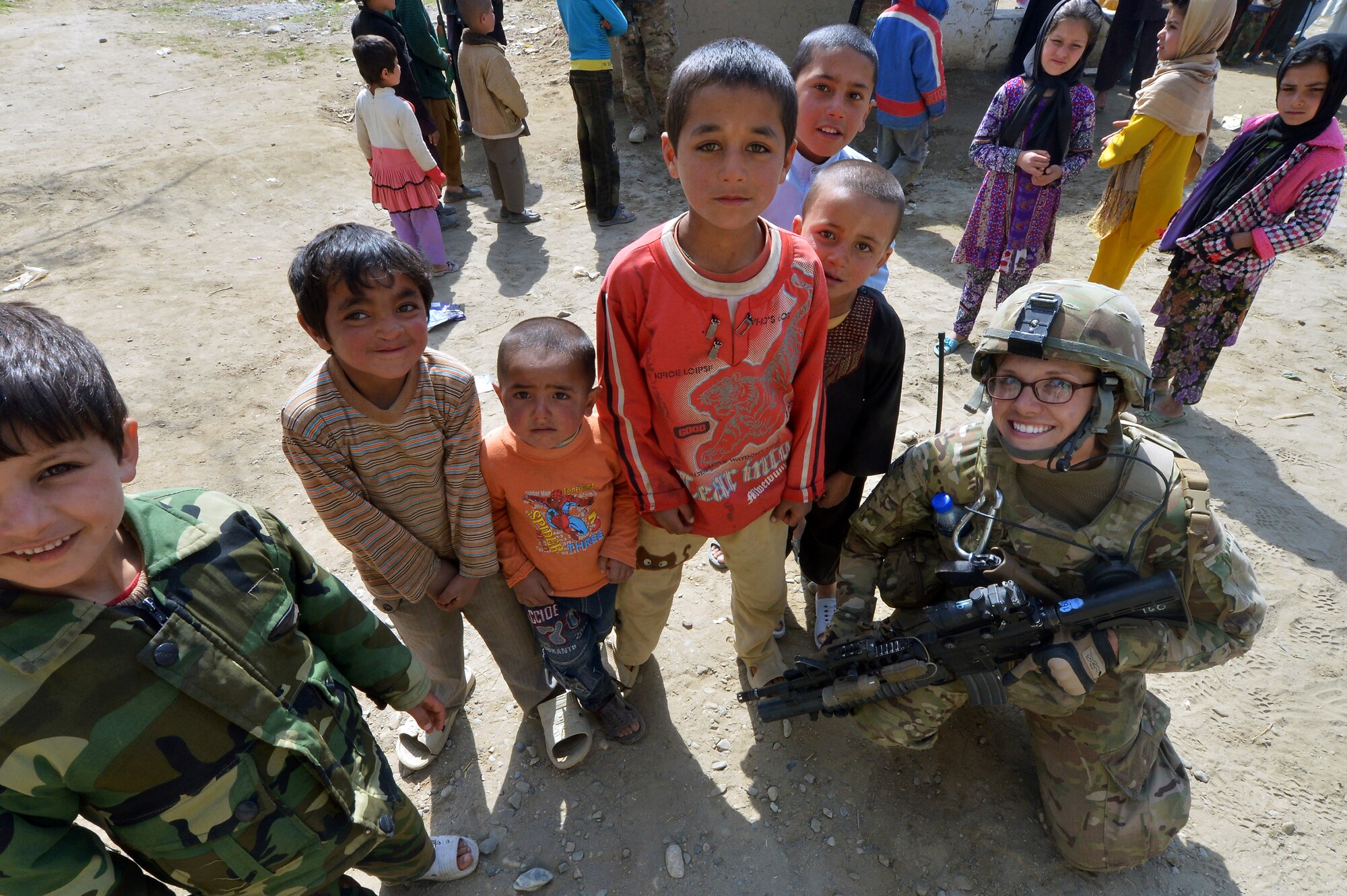 Staff Sgt. Elizabeth Rosato, 755th Expeditionary Security Forces Squadron Reaper Team 1 member, meets with local Afghan children outside of Bagram Airfield, Afghanistan, March 11, 2013.  The Reaper team conducts patrols near Bagram Airfield to counter improvised explosive devices and indirect fire attacks as well as to engage locals’ support in protecting the base. (U.S. Air Force photo/Senior Airman Chris Willis)