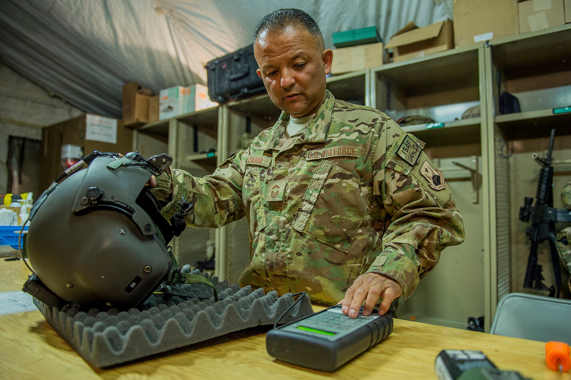 U.S. Air Force Senior Master Sgt. Vincent Aldama, an aircrew flight equipment specialist deployed to the 26th Expeditionary Rescue Squadron, inspects an HGU-56/P aircrew flight helmet on Camp Bastion, Afghanistan, March 8, 2013. Aldama is responsible for flight equipment such as helmets, oxygen masks, parachutes, flotation devices, survival kits, night vision goggles, anti-G garments, aircrew eye and respiratory protective equipment and other types of AFE. Aldama is from the 129th Rescue Wing, California Air National Guard, Moffett Federal Airfield, Calif. (U.S. Air Force photo/Tech. Sgt. Dennis J. Henry Jr.)