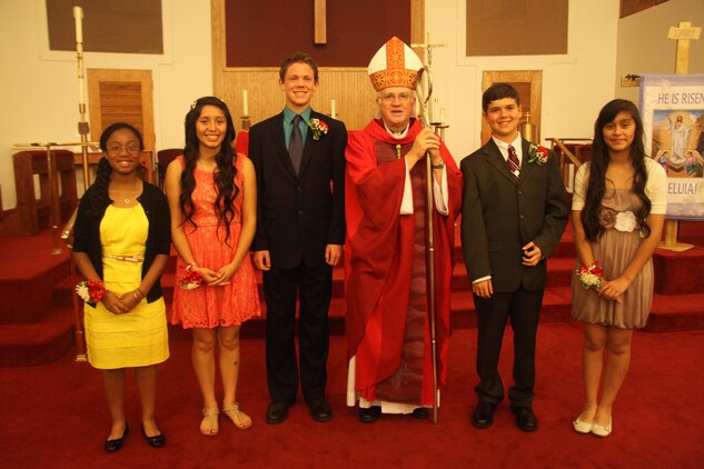 The confirmandi stand with Bishop Richard Higgins after being confirmed in the chapel aboard Marine Corps Air Station Beaufort, April 16. According to Catholic doctrine, in this sacrament they receive the Holy Spirit and become adult members of the Catholic Church. 