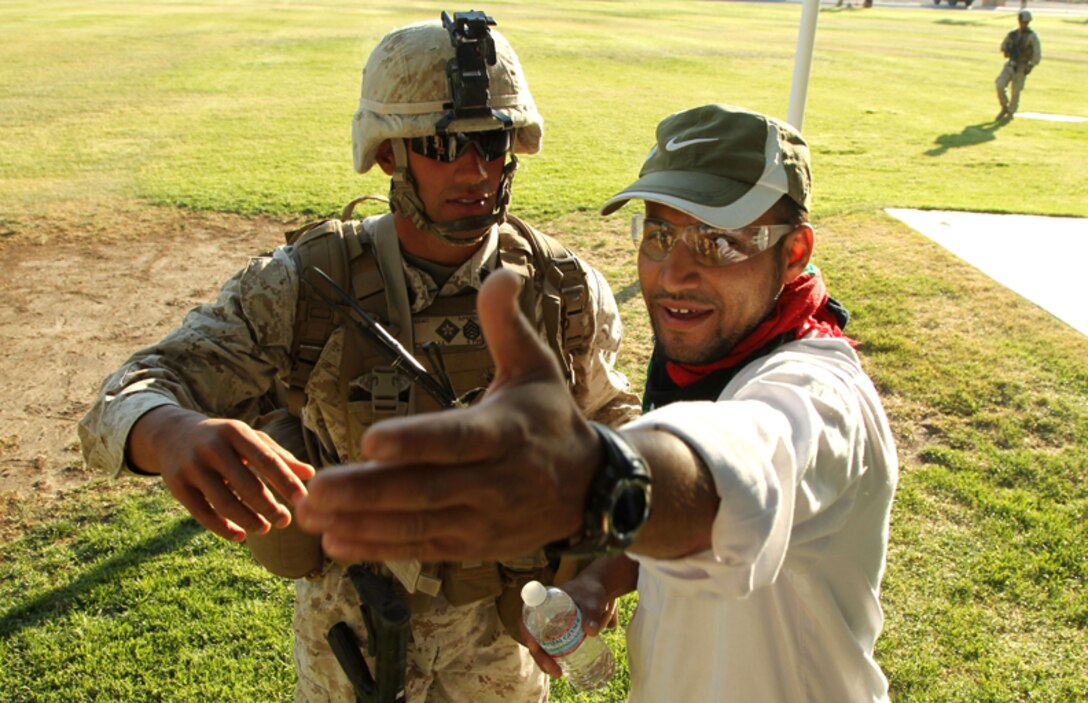 Staff Sgt. Alex Padilla, platoon sergeant, Company A, 1st Battalion, 6th Marine Regiment, performs crowd control during a noncombatant evacuation operation  exercise at Lance Cpl. Torrey L. Gray Field April 19, 2013. (Official USMC photo by Cpl. William J. Jackson)
