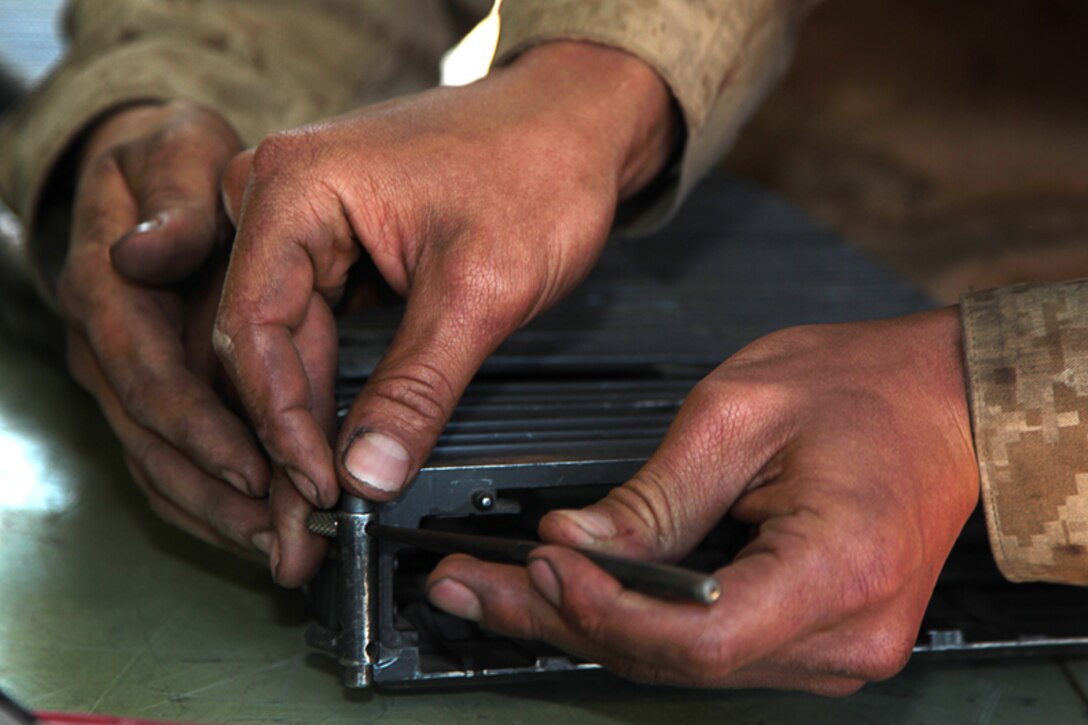 Light Armored Vehicle mechanics with Light Armored Reconnaissance Battalion fix a malfunctioning pin, preventing the LAV’s weapons system from firing during Table 6 qualifications at Range 500 April 12, 2013.