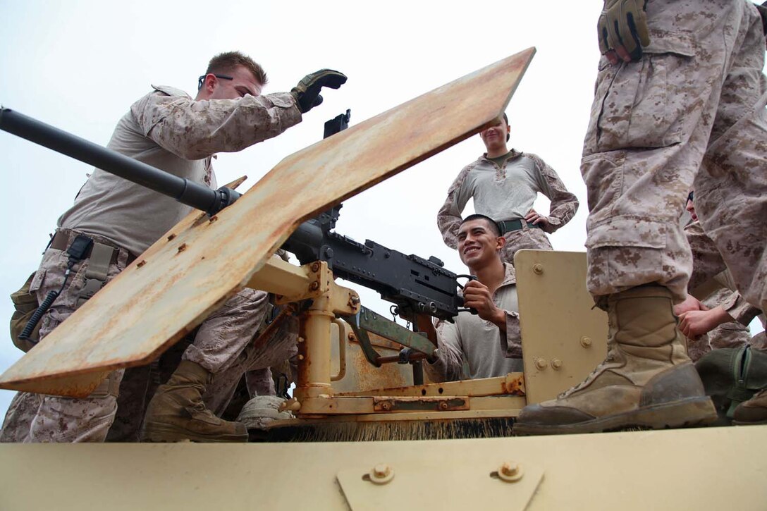 130429-M-VZ265-012 USS RUSHMORE (April 29, 2013) Corporal Joshua Plachy (left), military policeman, Military Police Detachment, Combat Logistics Battalion 15, 15th Marine Expeditionary Unit, conducts a safety brief on the .50 caliber machine gun during a live-fire exercise on the flight deck of USS Rushmore, April 29. The servicemembers fired more than 14,000 rounds to ensure everyone was proficient with all of the battalion’s weapon systems. The 15th MEU is comprised of approximately 2,400 Marines and sailors and is deployed as part of the Peleliu Amphibious Ready Group. Together, they provide a forward-deployed, flexible sea-based Marine Air Ground Task Force capable of conducting a wide variety of operations ranging from humanitarian aid to combat. Plachy, 25, is from Chicago. (U.S. Marine Corps photo by Cpl. Timothy Childers/Released)