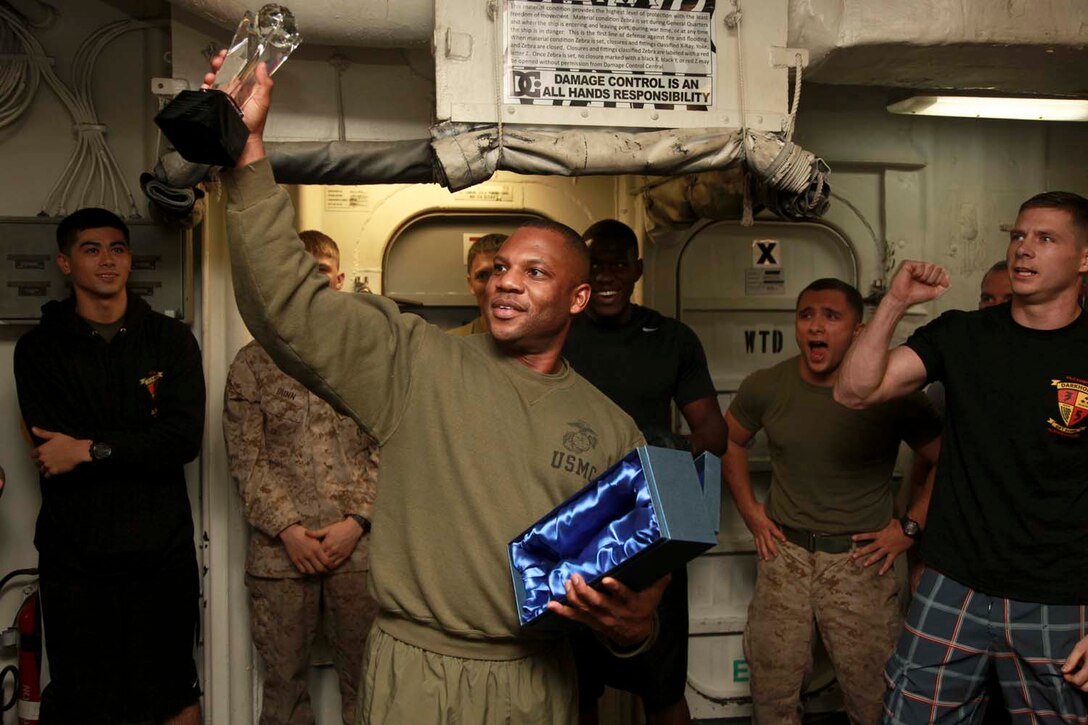 USS PELELIU (April 28, 2013) Sergeant Maj. John W. Scott, sergeant major, 15th Marine Expeditionary Unit, holds up the Campbell Cup during the Campbell Cup held in the gym of USS Peleliu, April 28. The challenge was the final competition of the Campbell Cup, a competition that brought teams from within the 15th Marine Expeditionary Unit and Peleliu Amphibious Ready Group against each other. This two-night event pitted the Command Element’s team against Kilo Company’s team in a showdown for the coveted Campbell Cup. The 15th MEU is deployed as part of the Peleliu Amphibious Ready Group and is comprised of approximately 2,400 Marines and sailors. Together with Amphibious Squadron Three, they provide a forward-deployed, flexible sea-based Marine Air Ground Task Force capable of conducting a wide variety of operations ranging from humanitarian aid to combat. (U.S. Marine Corps photo by Cpl. John Robbart III/Released)