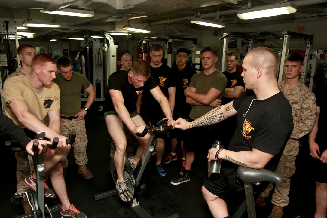 USS PELELIU (April 27, 2013) Marines with Kilo Company, Battalion Landing Team 3/5, 15th Marine Expeditionary Unit, cheer on Lance Cpl. Alex P. Labier, a rifleman with 2nd Platoon, while he bikes during the Campbell Cup held in the gym of USS Peleliu, April 27. The challenge was the final competition of the Campbell Cup, a competition that brought teams from within the 15th Marine Expeditionary Unit and Peleliu Amphibious Ready Group against each other. This two-night event pitted the Command Element’s team against Kilo Company’s team in a showdown for the coveted Campbell Cup. The 15th MEU is deployed as part of the Peleliu Amphibious Ready Group and is comprised of approximately 2,400 Marines and sailors. Together with Amphibious Squadron Three, they provide a forward-deployed, flexible sea-based Marine Air Ground Task Force capable of conducting a wide variety of operations ranging from humanitarian aid to combat. Labier, 21, is from Ware, Mass. (U.S. Marine Corps photo by Cpl. John Robbart III/Released)