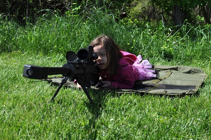 Ariel Kisiah, daughter of Aimee and Stephen Kisiah, both with Resource Management, checks out a weapon at the Infantry Combat Equipment display April 25 during Marine Corps Systems Command's "Bring Your Daughters and Sons to Work Day." 