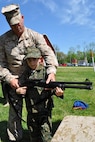Capt. Jason Latta of Programs helps his son, Jack, with a weapon at the Infantry Combat Equipment display April 25 during Marine Corps Systems Command's "Bring Your Daughters and Sons to Work Day." 