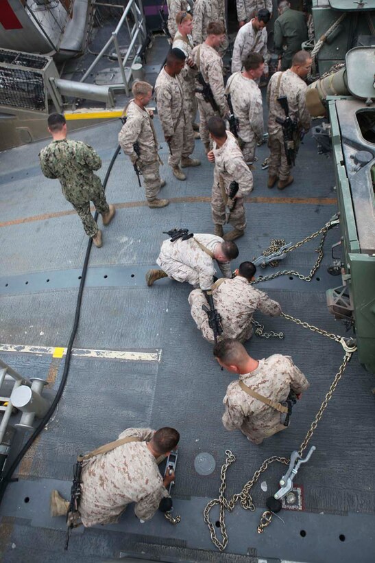 Marines serving with Alpha Company, 1st Light Armored Reconnaissance Battalion utilize "griping" training, a process to tie down their light armored vehicles to landing craft air cushion, during a strategic mobility exercise here, April 29, 2013. Landing craft air cushions are capable of carrying up to 65 tons over 70 miles between land and sea. The Marines learned the basics of loading and unloading from the hovercraft to prepare for upcoming deployments.   (U.S. Marine Corps photo Cpl. Robert J. Reeves/Released)
