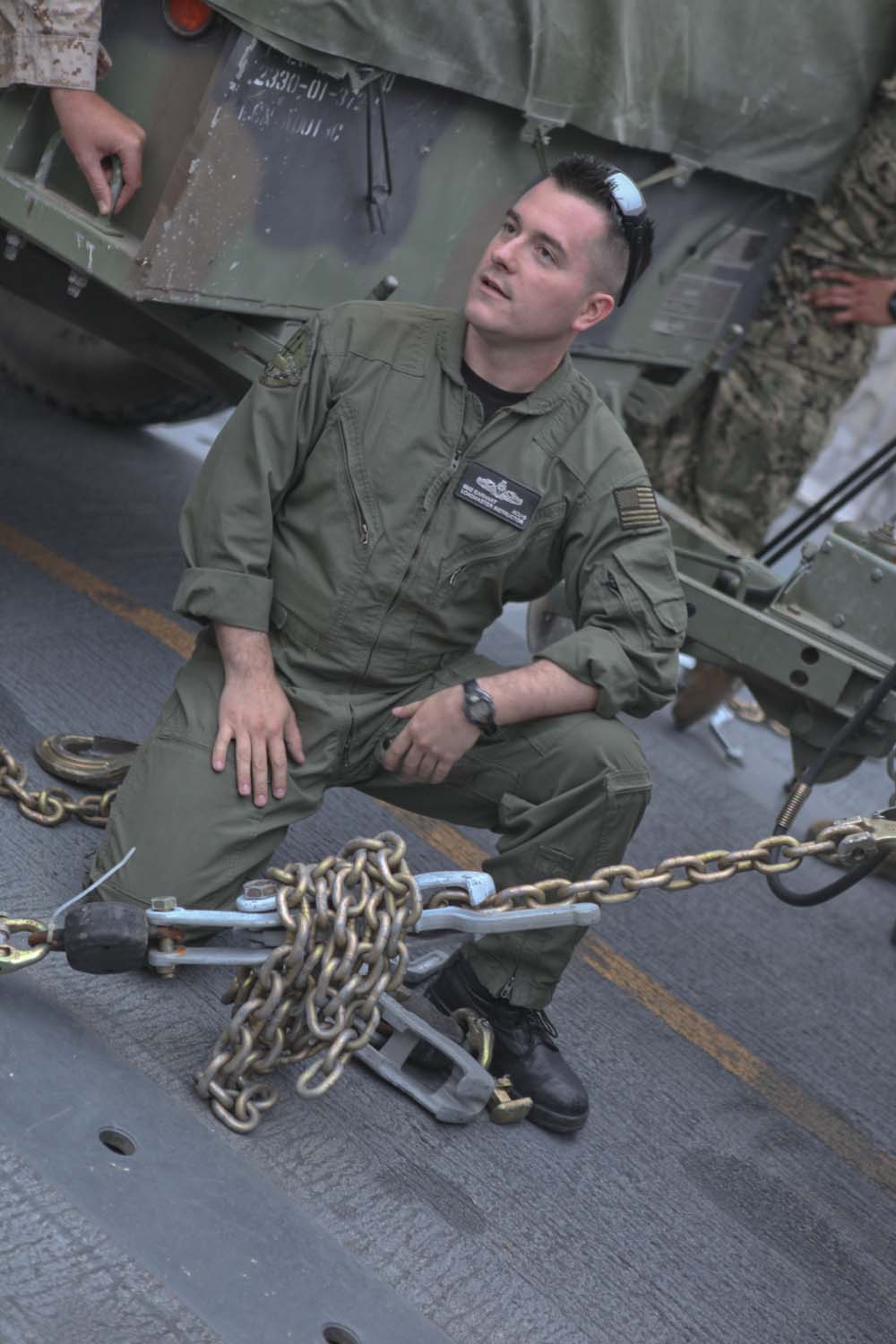 Petty Officer 2nd Class Derek Earhart, a native of Fremont, Ohio, who serves as loadmaster with Assault Craft Unit 5, addresses the safety procedures of "griping," a process to tie down light armored vehicles to a landing craft air cushion, with the Marines of 1st Light Armored Reconnaissance Battalion prior to a training exercise here April 29, 2013. The griping exercise was designed to teach the Marines the basics of beach landings with their LAVs carried by a landing craft air cushion, making 1st LAR a more mobile force. Landing craft air cushions are capable of carrying up to 65 tons over 70 miles between land and sea. (U.S. Marine Corps photo Cpl. Robert J. Reeves/Released)