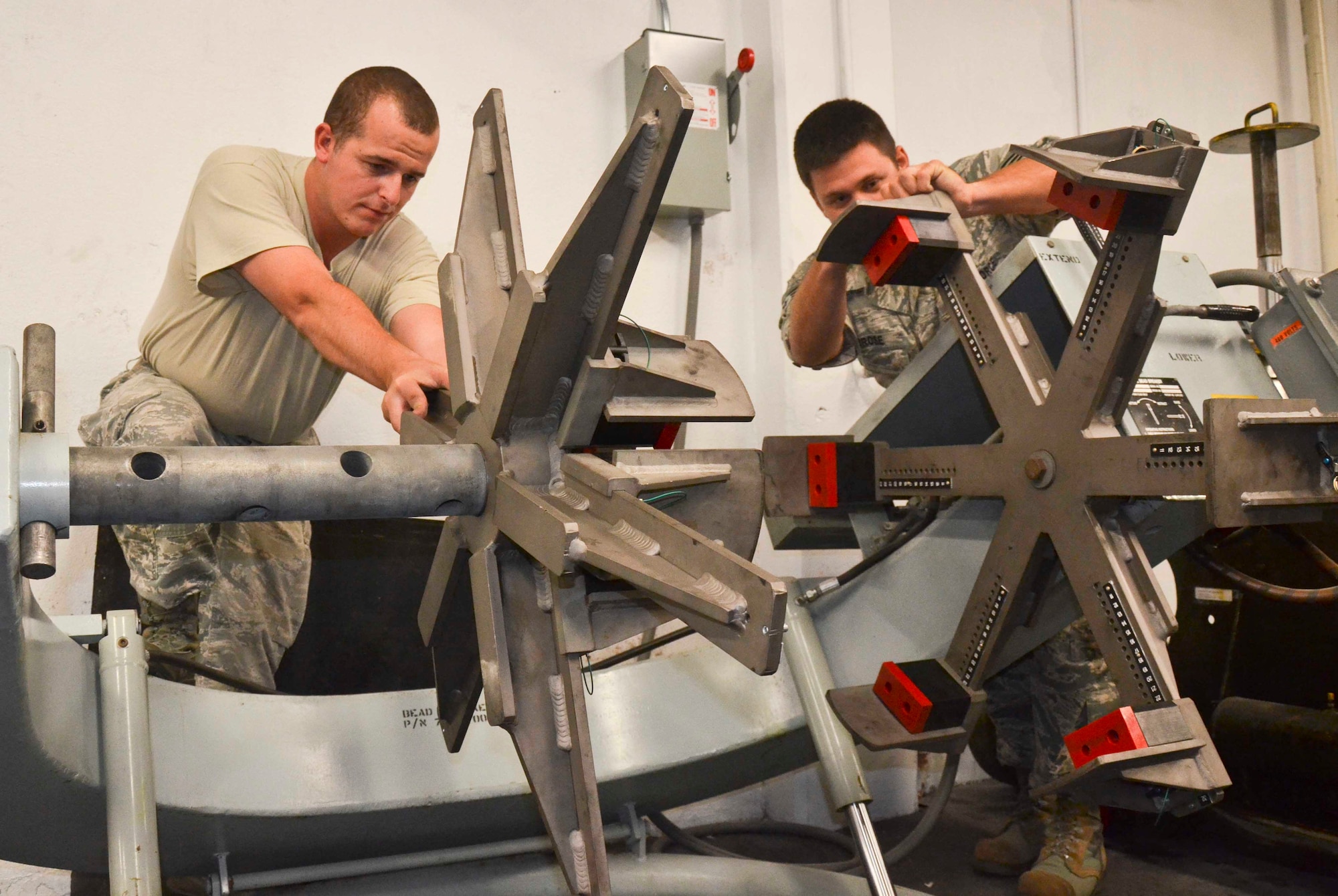 Staff Sgt. Jan Stevens and Staff Sgt. Tyler Ambrose, both 36th Maintenance Squadron Wheel and Tire Shop specialists, test out the shop’s new universal adapters for the aircraft tire bead breaker on Andersen Air Force Base, Guam, April 11, 2013.  The new tool allows the shop to fully accommodate tires for the B-52 Stratofortress and any other aircraft using Andersen’s flightline. Having the new equipment will save the Air Force roughly $32,000 annually. (U.S. Air Force photo by Staff Sgt. Veronica McMahon/Released)