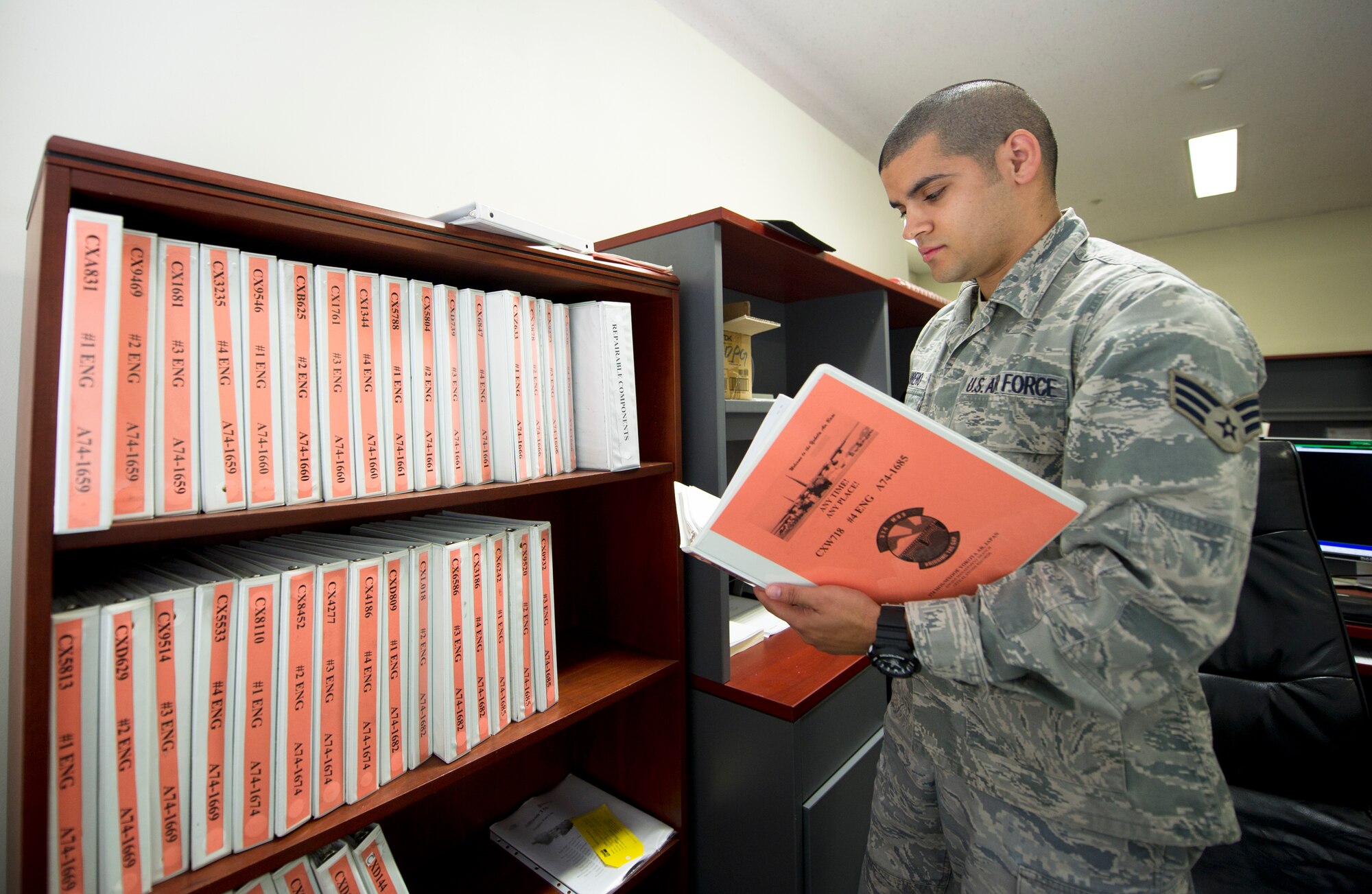 YOKOTA AIR BASE, Japan -- Senior Airman Randy Marrero, 374th Maintenance Operation Squadron engine maintenance scheduler, reviews an engine jacket file April 17, 2013, at Yokota Air Base, Japan. Marrero and the other members of the engine management section meet mission requirements by obtaining accurate information and reporting on the status of the engines and components. (U.S. Air Force photo by Staff Sgt. Stacy Moless)     