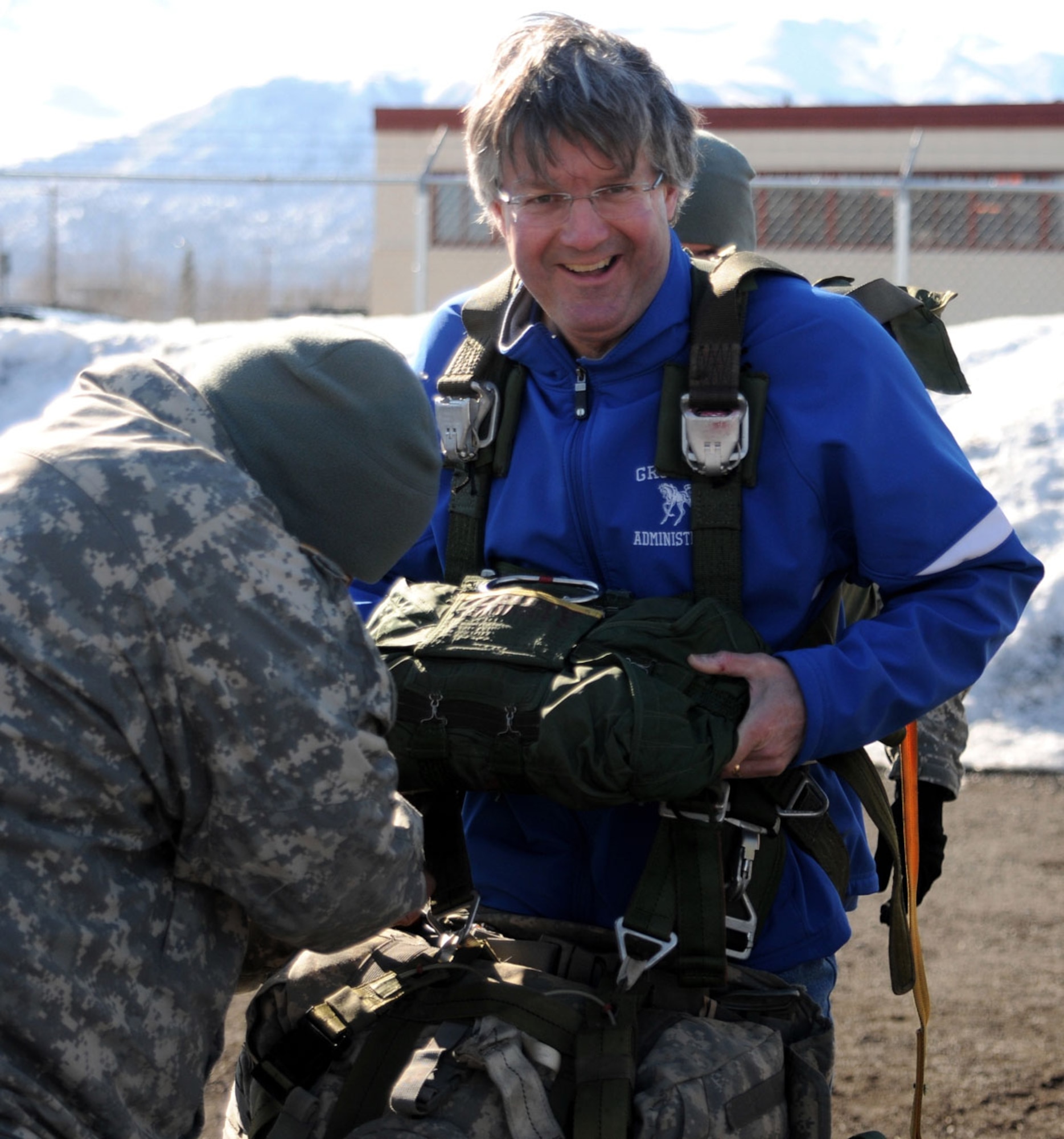 Bobby Jefts, principal of Gruening Middle School, Anchorage, is helped with the Army T10D parachute during a School Partnership Program installation tour April 25. (U.S. Army photo/Staff Sgt. Jeffrey Smith)