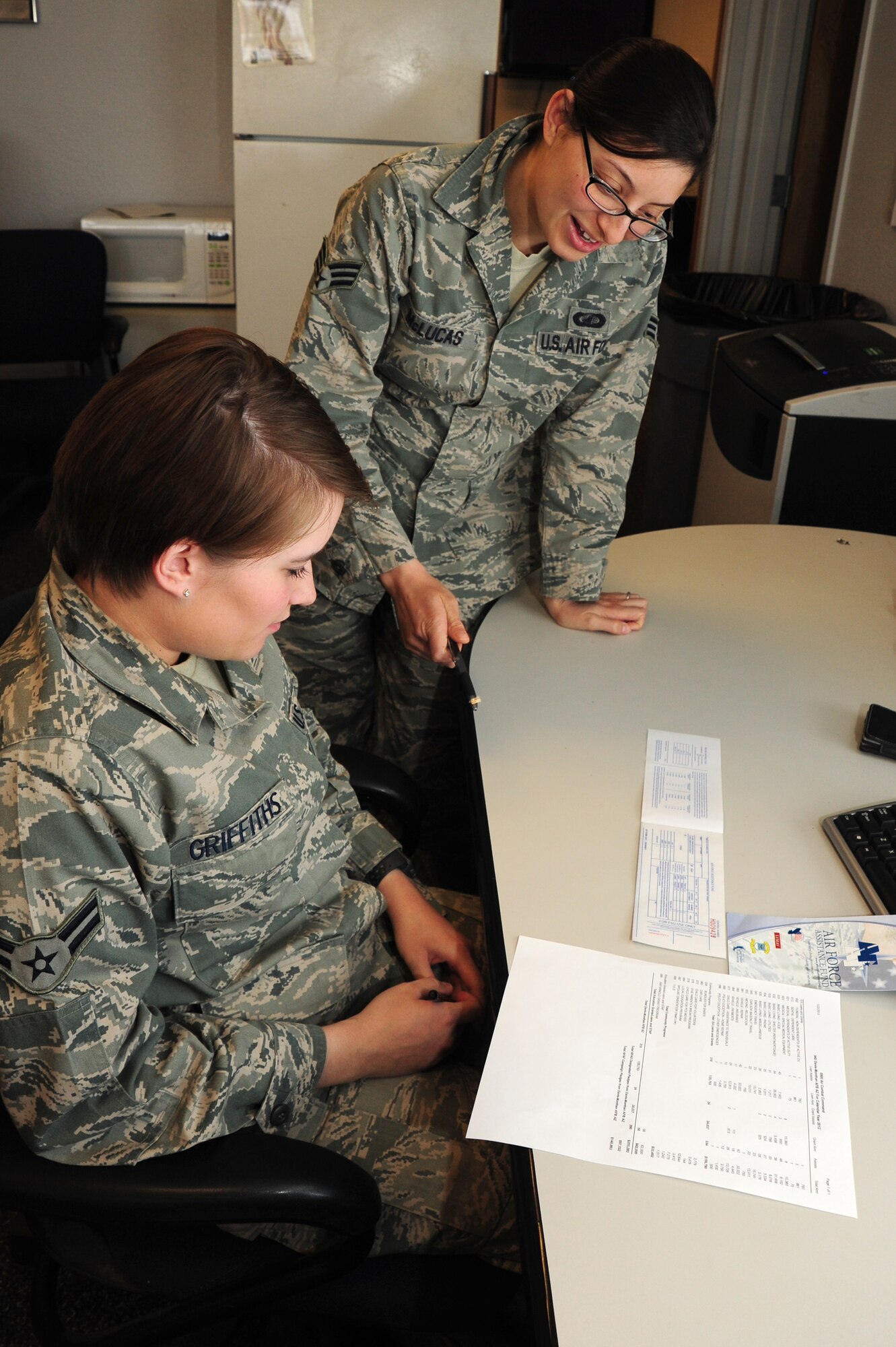 U.S. Air Force Senior Airman Danielle McLucas, 355th Comptroller Squadron financial analyst, assists Airman 1st Class Christine Griffiths, 355th Fighter Wing Public Affairs photojournalist, with filling out an Air Force Assistance Fund form at Davis-Monthan Air Force Base, Ariz., May 1, 2013. McLucas is the fighter wing’s AFAF representative. (U.S. Air Force photo by Senior Airman Camilla Griffin/Released)