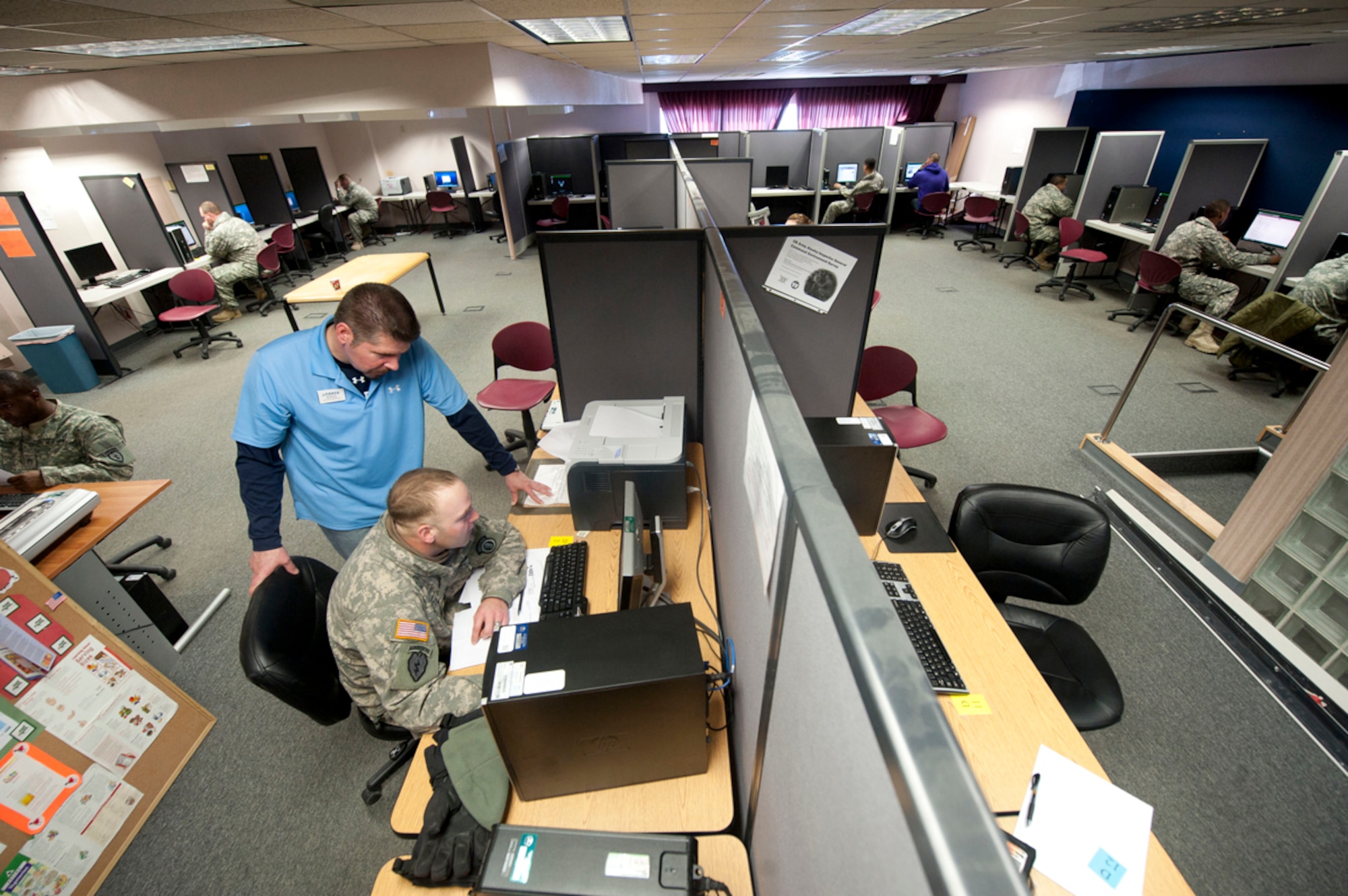Bill Miracle helps a Soldier print a training certificate in the Warrior Zone in building 655 on Joint Base Elmendorf-Richardson, Alaska, April 15. The Warrior Zone offers free movies and games, and rooms to watch and play them, as well a pool tables and other entertainment while also providing computers and printers for official training and mission support. Miracle is the director of the Warrior Zone. (U.S. Air Force photo/Staff Sgt. Robert Barnett)