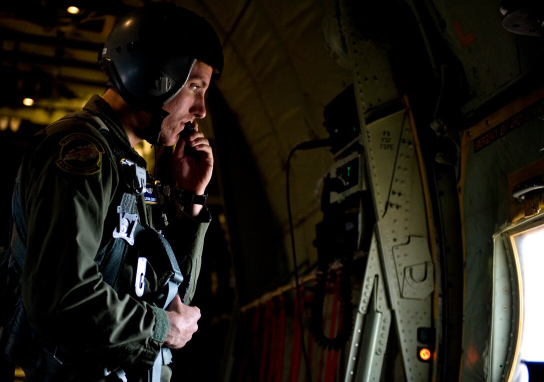 U.S. Air Force Airman 1st Class Ryan Louden, 40th Airlift Squadron (AS), 317th Airlift Group, Dyess Air Force Base, Texas, communicates with aircrew members during a simulated troop drop over western Texas, April 25, 2013. The intent of the mission was to establish and maintain air superiority, eliminate simulated surface-to-air threats, successfully airdrop a ranger regiment onto an airfield, establish communications with ground force commanders and eliminate enemy ground forces.  (U.S. Air Force photo by Airman 1st Class Charles Rivezzo/Released) 