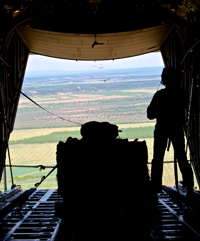 U.S. Air Force Airman 1st Class Ryan Louden, 40th Airlift Squadron (AS), 317th Airlift Group, Dyess Air Force Base, Texas, stands on the ramp of a C-130J during a 12-ship formation over western Texas, April 25, 2013. During the joint force integration exercise, aircraft were targeted by simulated tracking radar, anti-aircraft artillery and surface-to-air missiles from the Snyder Electronic Scoring Site, adding to the realism of the scenario. (U.S. Air Force photo by Airman 1st Class Charles Rivezzo/Released) 