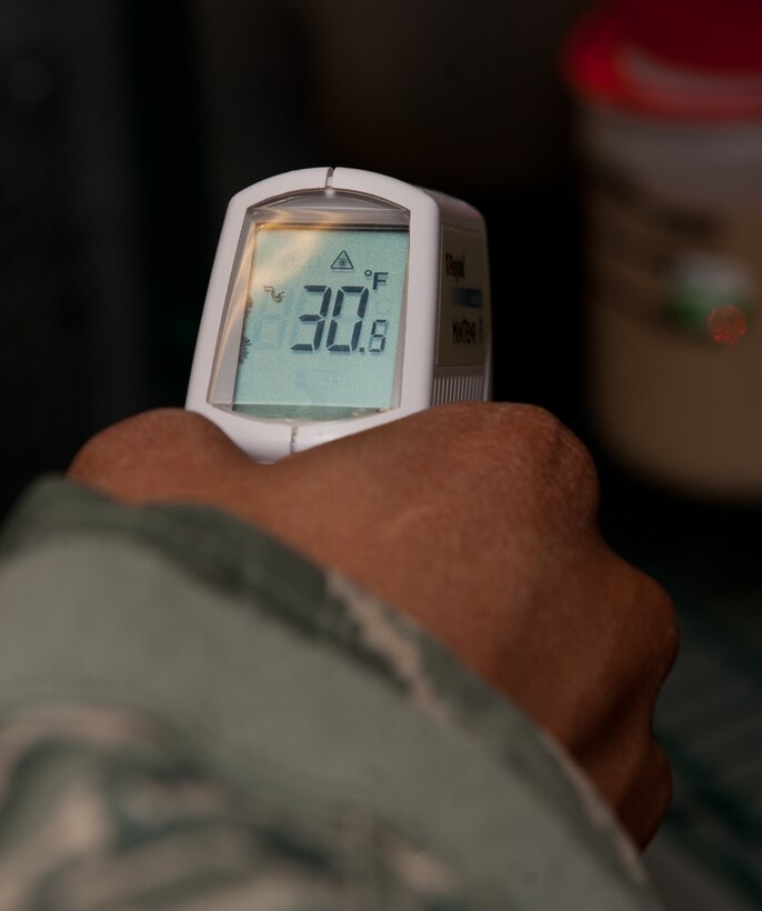 Senior Airman Sylvester Snell, 28th Medical Operations Squadron public health technician, measures the surface temperature of food products during a health inspection at the Exchange food court on Ellsworth Air Force Base, S.D., April 18, 2013. Refrigerators maintain a temperature below 42 degrees Fahrenheit to ensure food remains safe for consumption. (U.S. Air Force photo by Airman 1st Class Kate Thornton-Maurer/Released)