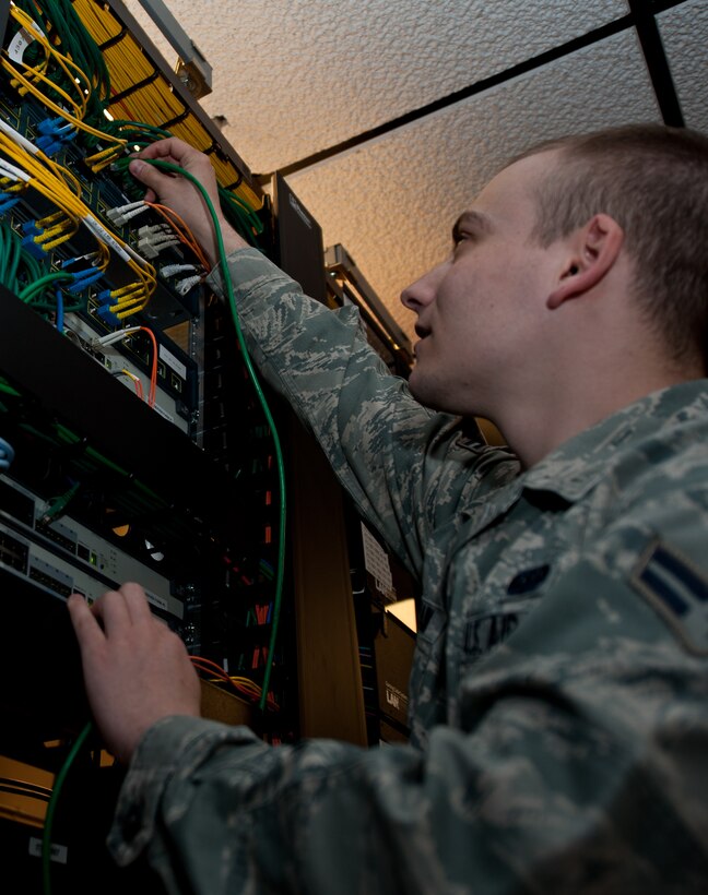 Airman 1st Class Adam Chastain, 28th Communications Squadron cyber transport systems technician, inspects the link status of a fiber cable to ensure network connection at Ellsworth Air Force Base, S.D., April 25, 2013. This network allows cyber transport system technicians to access customer computer accounts remotely and quickly resolve issues. (U.S. Air Force photo by Airman 1st Class Alystria Maurer/Released)