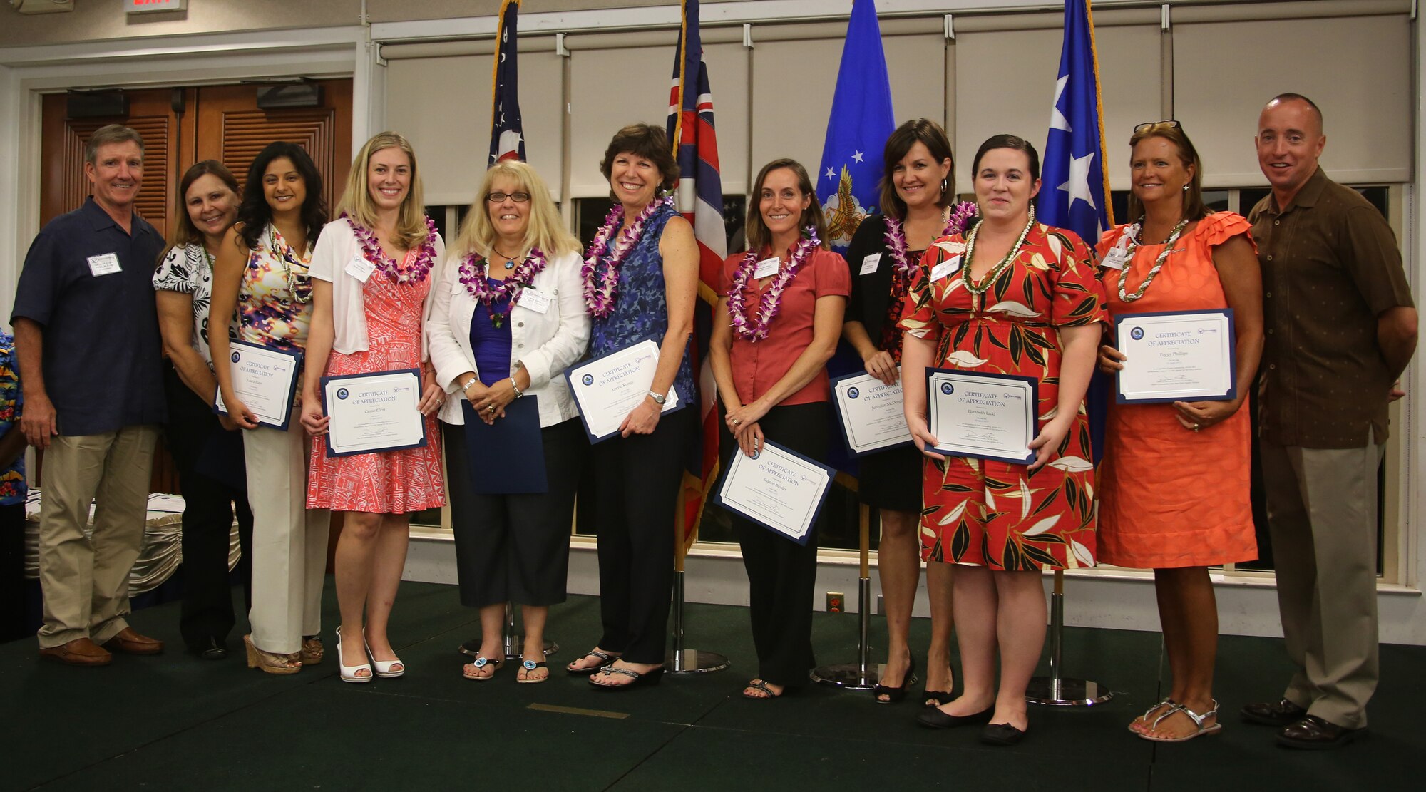 Gen. Herbert J. “Hawk” Carlisle, Pacific Air Forces commander, far left, and Col. Dann S. Carlson, 647th Air Base Group commander, far right, pose for a group photo in recognition of the members of Hickam key spouses during an appreciation ceremony at the Tradewinds Enlisted Club at Joint Base Pearl Harbor-Hickam, Hawaii, April 25, 2013. The Hickam Key Spouse program enhances mission readiness by facilitating the flow of communication between spouses, leadership and base agencies.  (Courtesy photo)