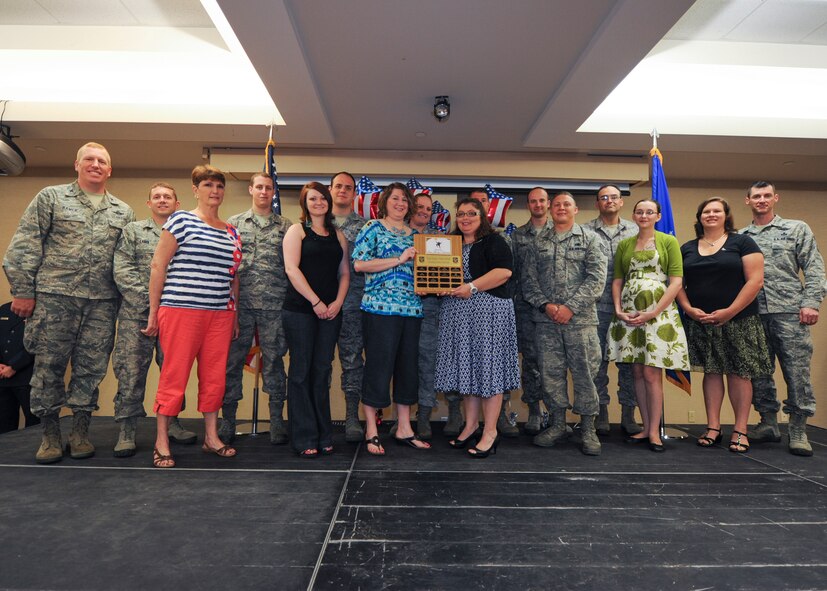 Members of Team Airman’s Attic are awarded the Outstanding Volunteer Award during the 2013 Volunteer Recognition Ceremony at Moody Air Force Base, Ga., April 25, 2013. The Airman’s Attic offers young Airmen and their families a place to get household items, clothes, furniture and children’s toys at no cost. (U.S. Air Force photo by Senior Airman Eileen Meier/Released) 