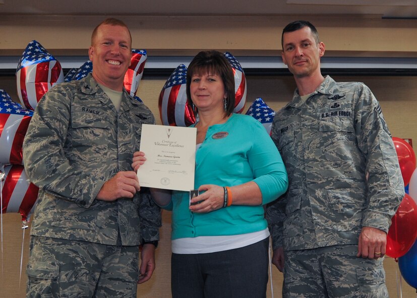U.S. Air Force Col. Steve Ramer, 23d Wing vice commander, and Chief Master Sgt. Matthew Wells, 23d WG command chief, present the Volunteer Excellence Award to Tamara Gavin, 23d Force Support Squadron human resources specialist, during the 2013 Volunteer Recognition Ceremony at Moody Air Force Base, Ga., April 25, 2013. Gavin was given the award for her significant amount of support of Relay for Life and the Department of Defense Marrow Donor Program. (U.S. Air Force photo by Senior Airman Eileen Meier/Released)
