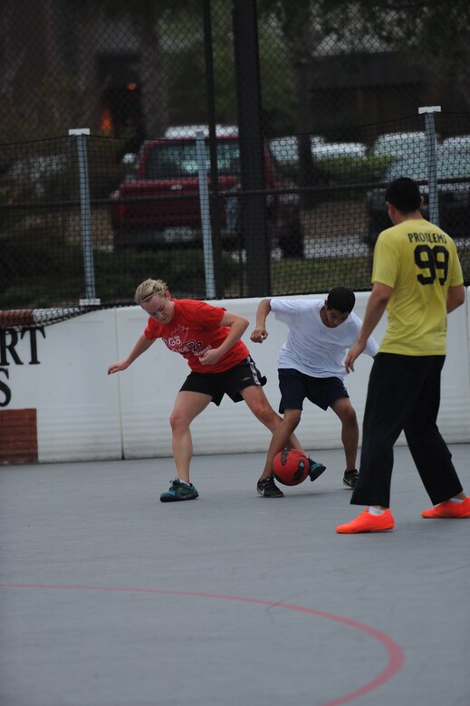 First Lt. Jennifer Brown (left), soccer player for Team Red, attempts to gain control of the ball from opposing members of the Special Tactics Training Squadron Team (right), during an arena soccer game at the Riptide Fitness Center’s hockey arena on Hurlburt Field, Fla, April 12, 2013. (U.S. Air Force photo by Senior Airman Kentavist P. Brackin) 