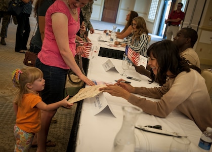 Actress Catherine Bell, from the television show Army Wives, signs an autograph during a meet and greet session April 26, 2013, at the Charleston Club on Joint Base Charleston – Air Base, S.C.  Army Wives tells the story of four women and one man who are brought together by their common bond - they all have military spouses. The series is based on the book "Under the Sabers: The Unwritten Code of Army Wives" by Tanya Biank and is produced by ABC Television Studio and The Mark Gordon Company. (U.S. Air Force photo/Senior Airman Dennis Sloan)