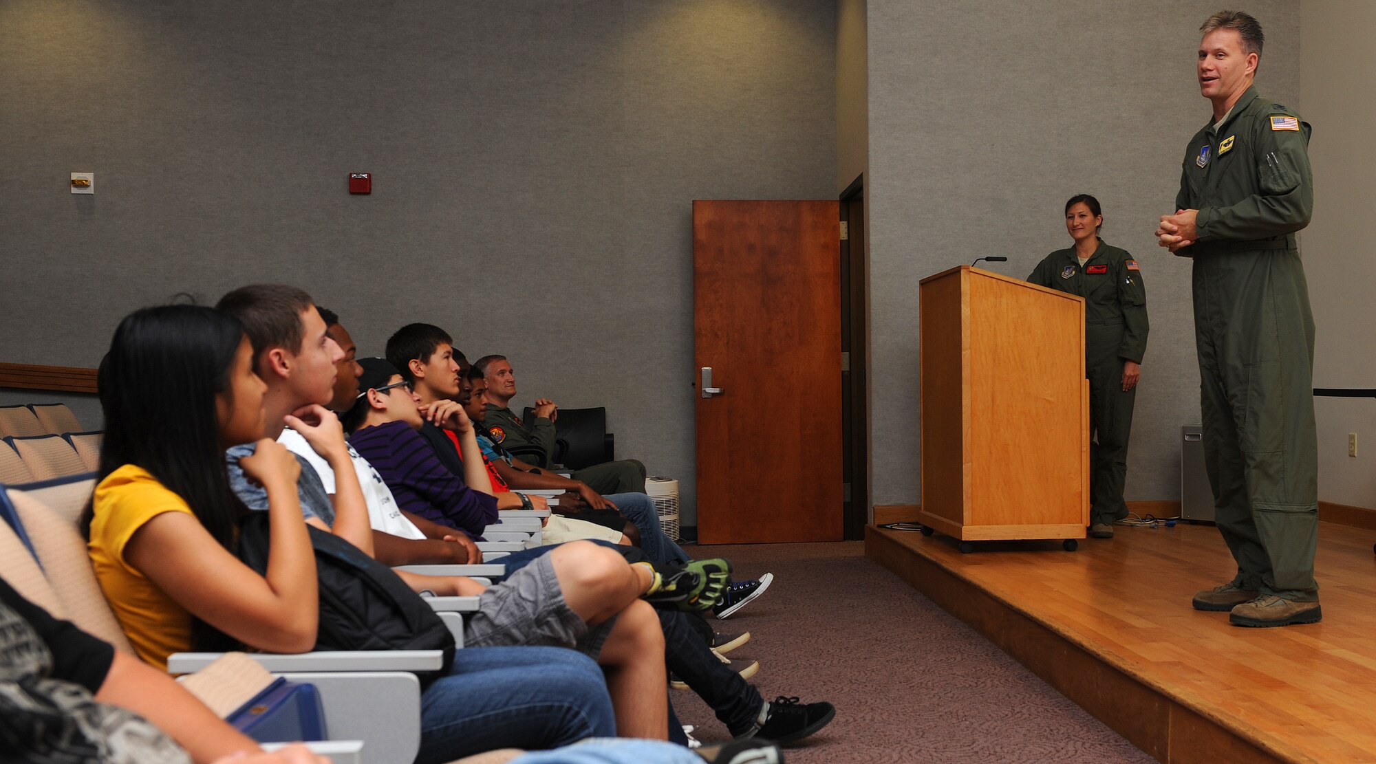 Col. David Baldessari, 15th Operations Group commander, right, and Capt. Angela Kimler, 535th Airlift Squadron training flight commander and Radford High School alumna, center, welcome Radford High School students during a career day at the C-17 operations building, at Joint Base Pearl Harbor-Hickam, Hawaii, April 25, 2013. The career day, which included a mission brief, squadron tour, C-17 simulator ride, and C-17 Globemaster III and KC-135 Stratotanker static displays are designed to give students a glimpse into a day in the life of an Air Force pilot. (U.S. Air Force photo/Tech. Sgt. Jerome S. Tayborn)