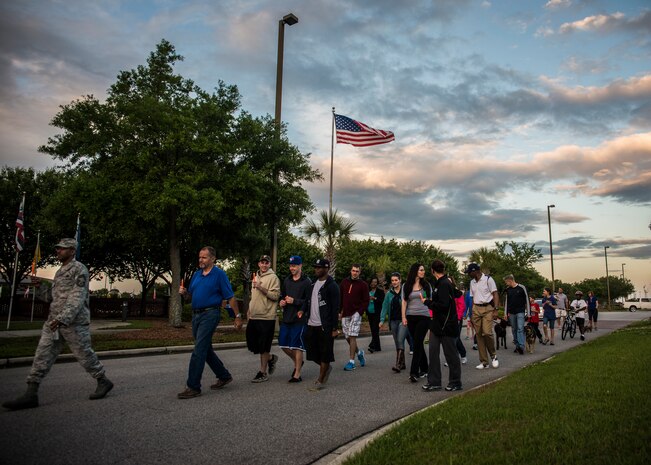 Airmen and their families, holding glow sticks, walk down Hill Blvd. during the “Take Back the Night Walk” to bring awareness to sexual assaults April, 30, 2013, at Joint Base Charleston – Air Base, S.C. The event marked the end of Sexual Assault Awareness Month. (U.S. Air Force photo/ Senior Airman Dennis Sloan)