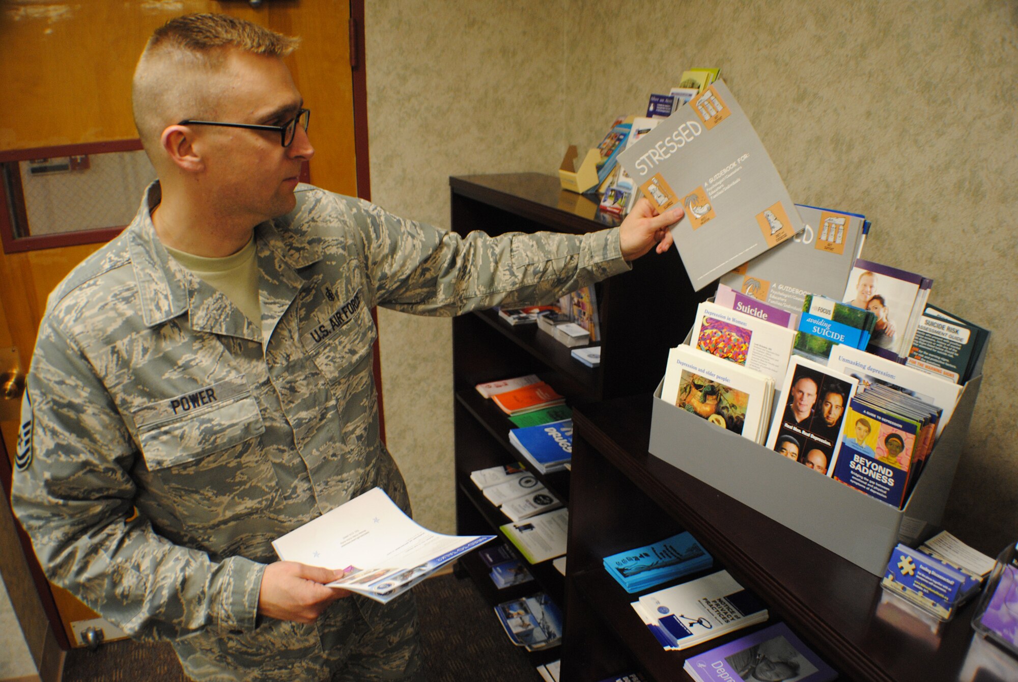 Master Sgt. Derek Power, 319th Medical Operations Squadron Mental Health flight chief, organizes booklets on stress management on April 25, 2013, at Grand Forks Air Force Base, N.D.  Power and the mental health staff provide patients and guests with a diverse selection of educational and informational materials to address various mental health concerns and topics, such as depression, anxiety and anger management. (U.S. Air Force photo/Staff Sgt. Luis Loza Gutierrez)
