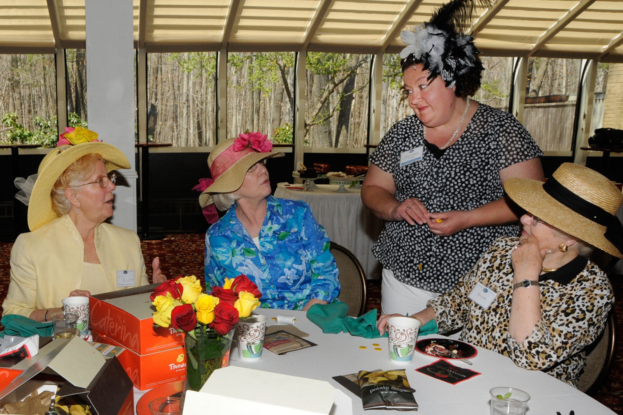 HANSCOM AIR FORCE BASE, Mass. -- Betsy Woolums (standing), Hanscom Spouses Club president, welcome (left to right) Alyce Richardson, Rita Prochaska, Pat Maxwell and Rita Lally, to a Kentucky Derby themed luncheon at the Minuteman Commons April 26. Members of the Hanscom Spouses Club gathered for their monthly luncheon with accessorized hats. (U.S. Air Force photo by Linda LaBonte Britt)