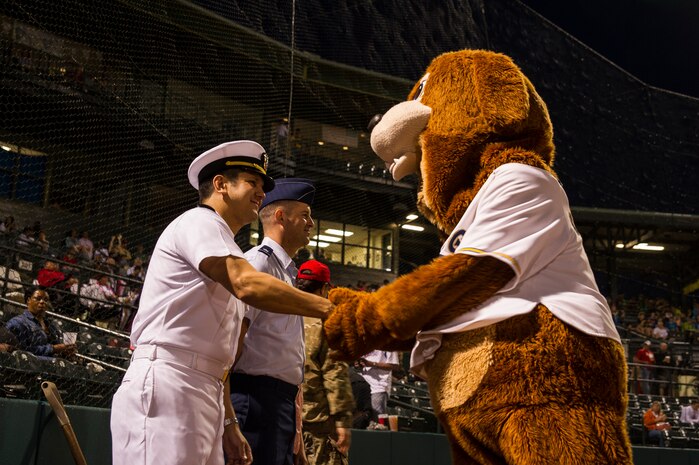 Lt. Cmdr. Victor Garza, incoming Nuclear Power Training Unit executive officer, shakes Charleston RiverDogs mascot Charlie’s paw, before the first pitch during the Charleston RiverDogs Military Appreciation Night game April 25, 2013, at the Joseph P. Riley, Jr. Park in Charleston, S.C. The Charleston RiverDogs hosted Military Appreciation night to show their support for the local military. (U.S. Air Force photo/ Senior Airman George Goslin)