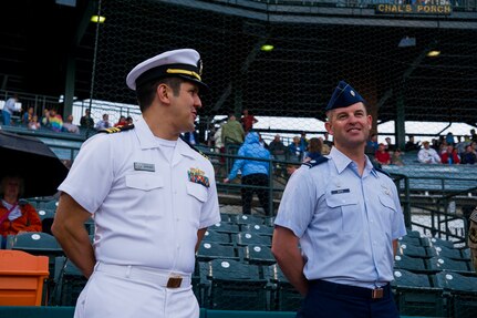 Lt. Cmdr. Victor Garza, incoming Nuclear Power Training Unit executive officer, and Lt. Col. Ryan White, 437th Aircraft Maintenance Squadron commander, wait to throw the first pitches during the Charleston RiverDogs Military Appreciation Night game April 25, 2013, at the Joseph P. Riley, Jr. Park in Charleston, S.C. The Charleston RiverDogs hosted Military Appreciation night to show their support for the local military. (U.S. Air Force photo/ Senior Airman George Goslin)