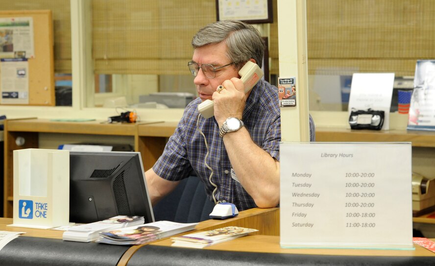 Anthony Bellucci, Barksdale Library Acquisitions technician, speaks with a customer on Barksdale Air Force Base, La., May 1, 2013. The library's hours recently changed due to the effects of sequestration. The new hours are 12 p.m. to 6 p.m. Monday, Tuesday, Thursday and Friday, 10 a.m. to 6 p.m. on Wednesdays, and 11 a.m. to 4 p.m. on Saturdays. Though hours are shorter, the library will continue to offer full services during the times they are open. (U.S. Air Force photo/Airman 1st Class Andrew Moua)