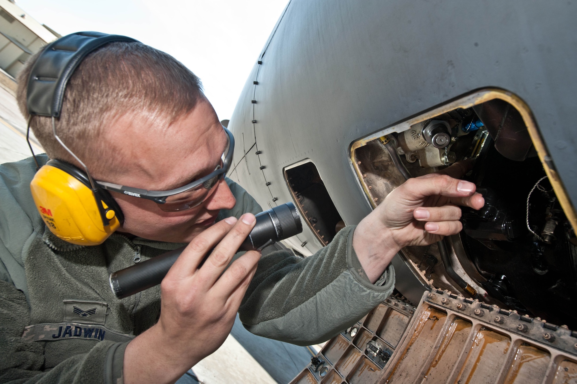 Senior Airman Brandon Jadwin, 28th Aircraft Maintenance Squadron electrical and environmental technician, checks the inside of an access panel to inspect an integrated drive generator system on a B-1 bomber at Ellsworth Air Force Base, S.D., April 4, 2013. Electrical and Environmental technicians inspect and evaluate B-1 bombers to determine the operational status of assigned assets. (U.S. Air Force photo by Airman 1st Class Zachary Hada/Released)
