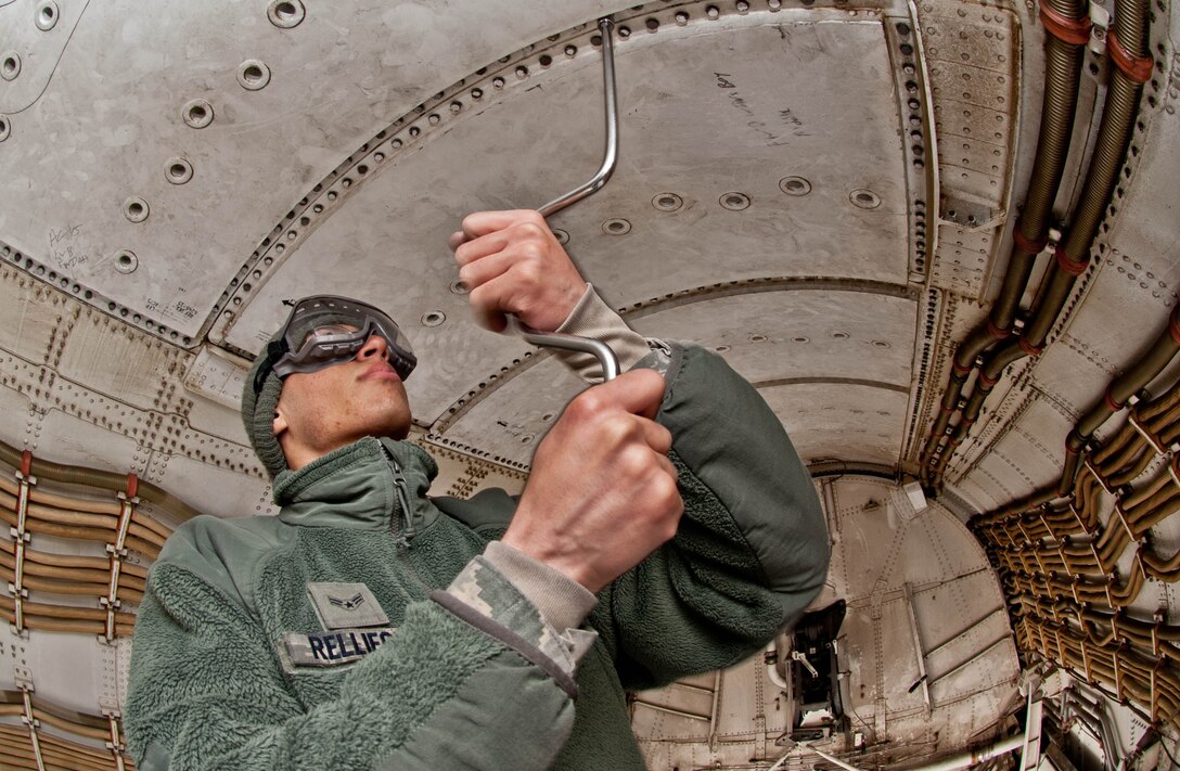 Airman 1st Class Kyle Relliford, 28th Aircraft Maintenance Squadron electrical and environmental technician, unscrews bolts to remove access panels on a B-1 prior to trouble shooting an issue at Ellsworth Air Force Base, S.D., April 4, 2013. Electrical environmental technicians perform maintenance on electrical system components and associated test equipment, including control, caution and warning panels, lighting equipment, frequency and load controls, anti-icing controllers, voltage regulators, actuators, relays and motors. (U.S. Air Force photo by Airman 1st Class Zachary Hada/Released)