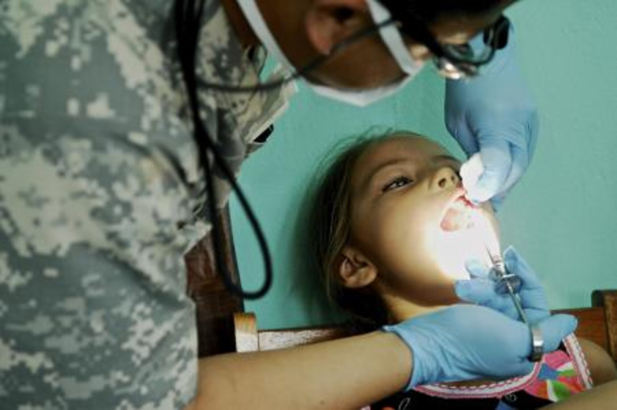 U.S. Army Capt. Blong Ly, general dentist assigned to the 352nd Combat Support Hospital, gives a young Belizean girl anesthetic at San Felipe School, Belize, April 24, 2013. Medical professionals from the U.S. and Canada provided free medical treatment during medical readiness training exercises throughout Belize as part of an on-going exercise known as New Horizons. The MEDRETES were designed to provide humanitarian assistance and medical care to people in several communities, while helping improve the skills of U.S. military medical forces. (U.S. Air Force photo by Master Sgt. James Law/Released)
