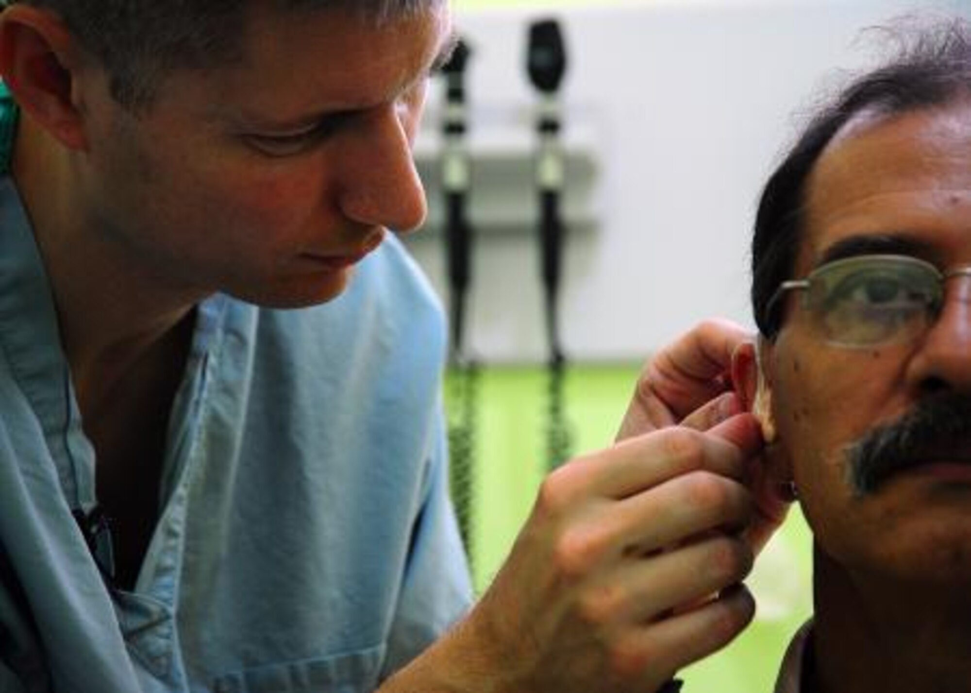 U.S. Air Force Capt. Quintin Hecht, audiologist from the 59th Surgical Specialty Squadron, Joint-Base San Antonio-Lackland, Texas, adjusts the fitting of a hearing aid on Cesar Alvarez during a surgery medical readiness training exercise at Western Regional Hospital in Belmopan, Belize, April 24, 2013. Medical professionals from the U.S. are providing free medical treatment at multiple medical readiness training exercises throughout Belize as part of an exercise known as New Horizons. The MEDRETES are designed to provide humanitarian assistance and medical care to people in several communities, while helping improve the skills of U.S. military medical forces. (U.S. Air Force photo by Tech Sgt. Tony Tolley/Released)