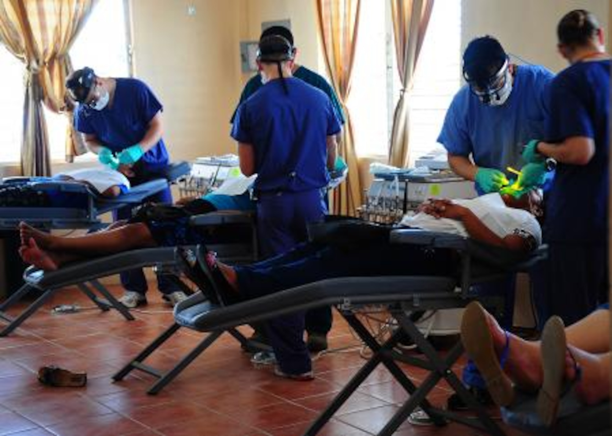 U.S. and Canadian dental personnel clean the teeth of Belizean patients during a dental readiness training exercise at the Punta Gorda Hospital annex in Punta Gorda, Belize, April 26, 2013. Dental professionals from the U.S. and Canada are providing free dental treatment at multiple readiness training exercises throughout Belize as part of an exercise known as New Horizons. The training exercises are designed to provide dental care to people throughout Belize, while helping improve the skills of U.S. and Canadian military medical forces. (U.S. Air Force photo by Tech Sgt. Tony Tolley/Released)