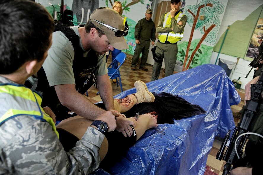 A tactical operator, part of the Illinois Special Weapons and Tactics team, tightens a tourniquet on a mannequin during training April 24, 2013 in Collinsville, Ill. The mannequin is very life-like, helping those being trained to get a feel for how it would be to apply a tourniquet on a real person. (U.S. Air Force photo/Airman Kristina Forst)
