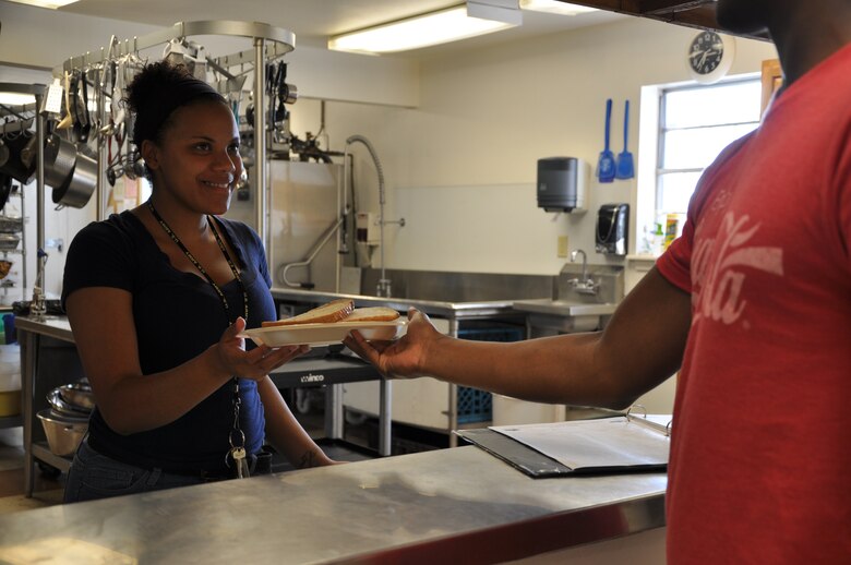 SAN ANGELO, Texas- Airman 1st Class Brionna Glover, 17th Medical Operations Squadron, hands a plate of food to a San Angelo resident at the Daily Bread soup kitchen, April 30. Glover volunteers her time at various programs such as the Boys and Girls Club of San Angelo, Meals for the Elderly and the soup kitchen. (U.S. Air Force photo/ Airman 1st Class Erica Rodriguez)