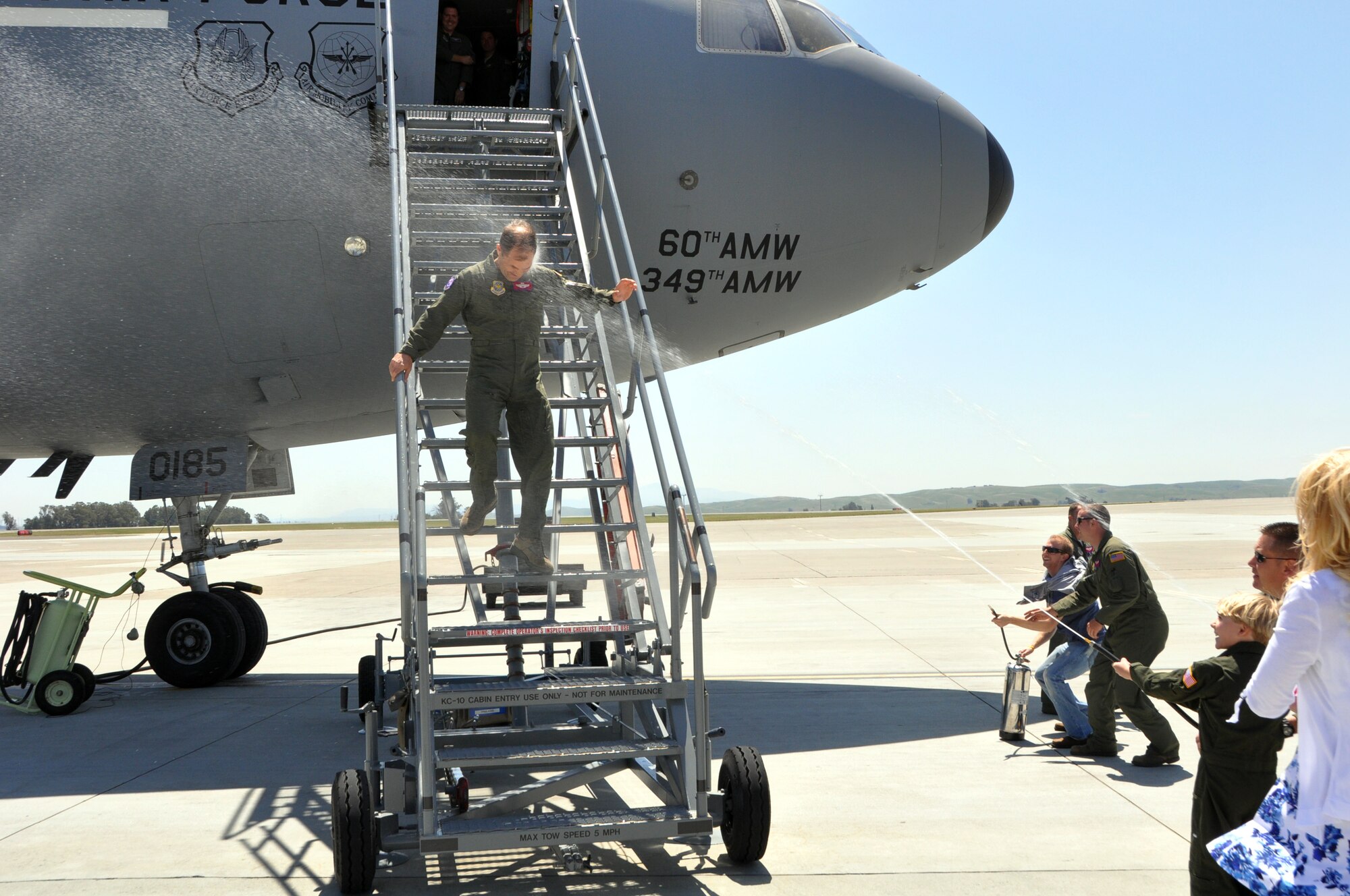 Lt. Col. Scott Moffat, 9th Aerial Refueling Squadron chief of training, gets sprayed with water by friends and family yesterday after finishing his final flight for the Air Force April 25, 2013. (U.S. Air Force photo/Staff Sgt. Patrick Harrower)