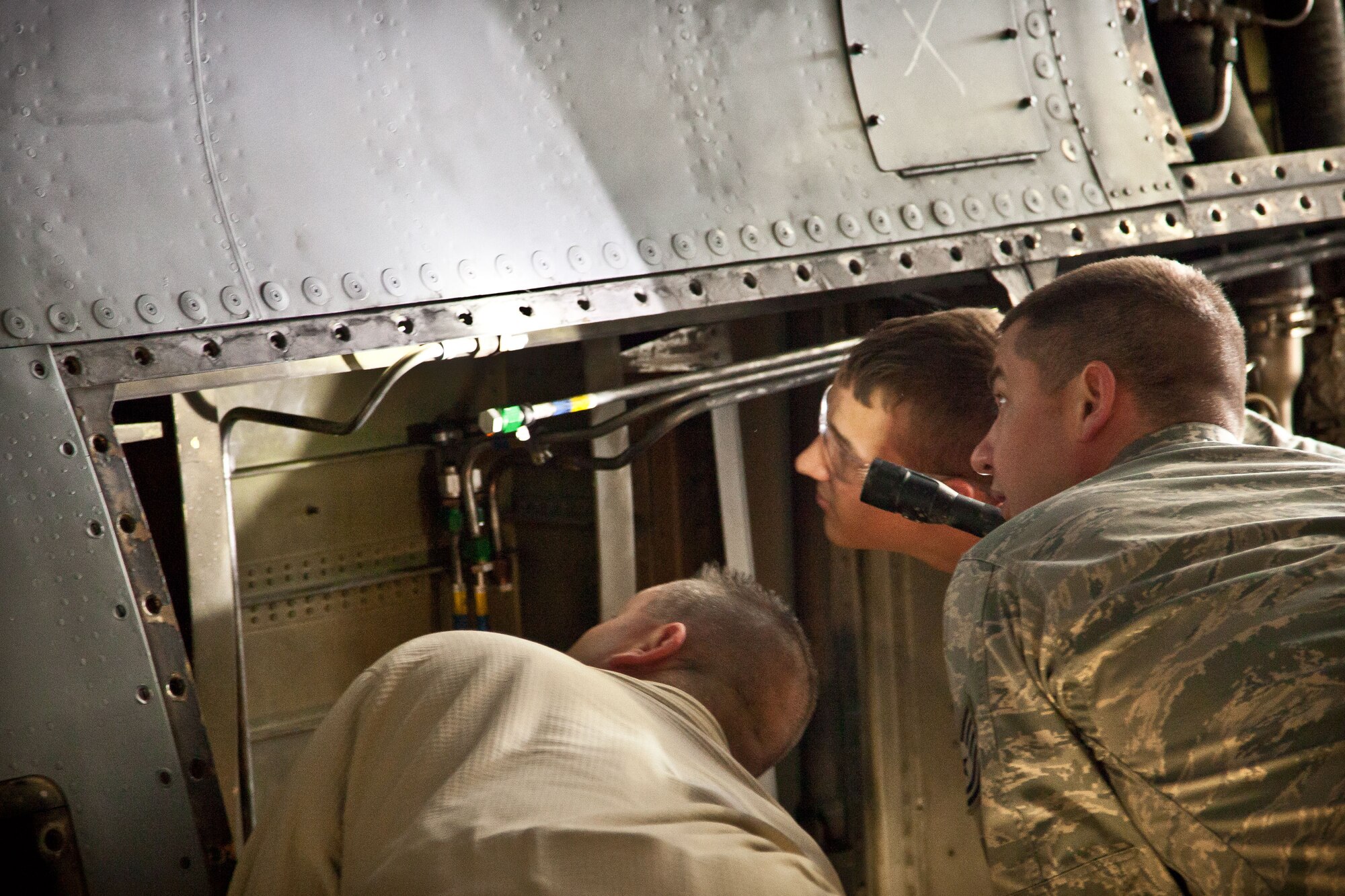 Tech. Sgt. Jeff Spaulding, Tech. Sgt. Michael Duzy, and Senior Airman Zachary  Blesener, 934th Maintenance Squadron, inspect a C-130 for a crack during an isochronal inspection at the Minneapolis-St. Paul Air Reserve Station, Minn.  (U.S. Air Force photo/Shannon McKay)